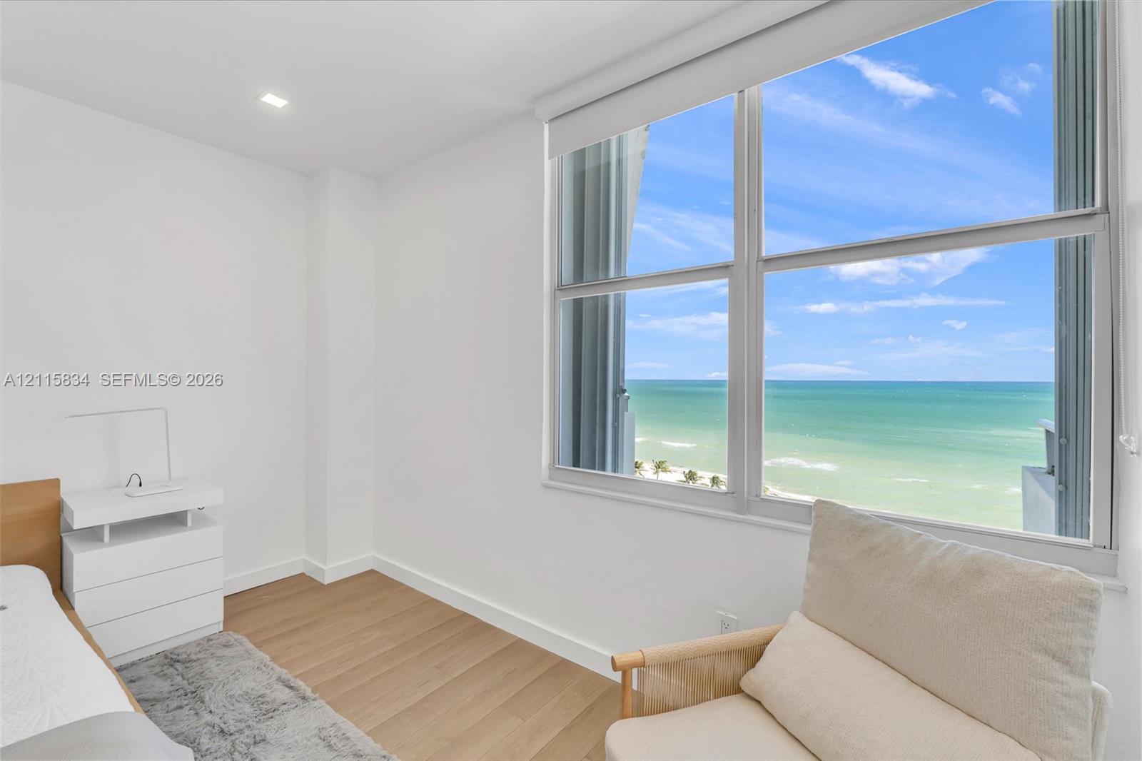Large windows with ocean scenery, wood-finish flooring, and recessed ceiling lighting