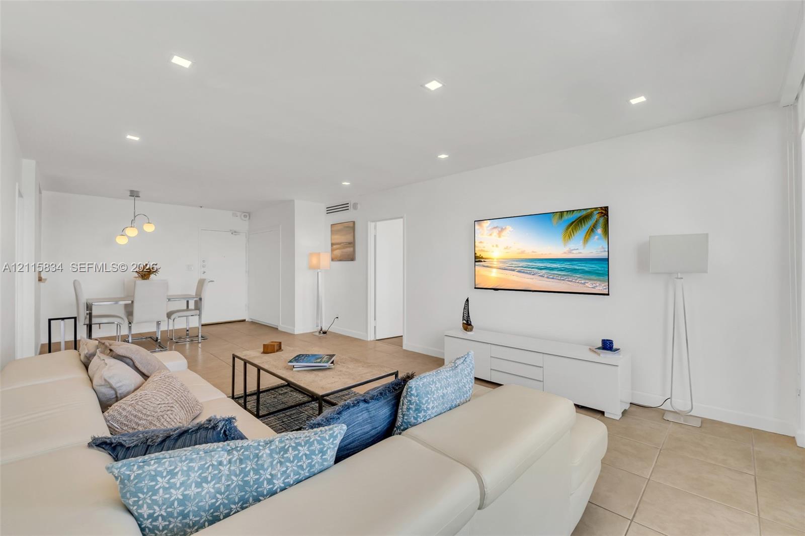 Open-concept interior featuring large-format tile flooring, recessed ceiling lighting, and crisp white wall finishes