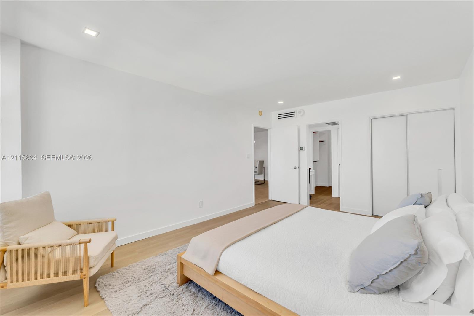 Room featuring wood-finish flooring, recessed lighting, and a sliding-door closet