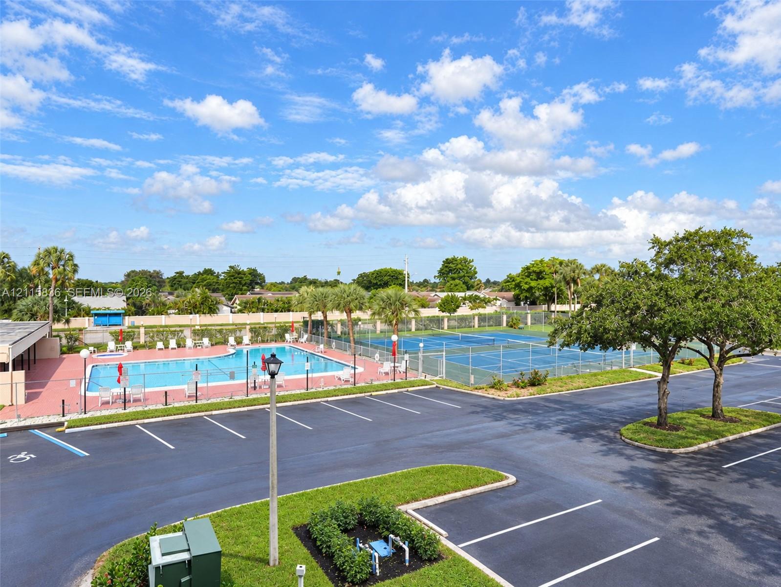 Recreational area featuring a fenced swimming pool and dual tennis courts with hard-court surfaces
