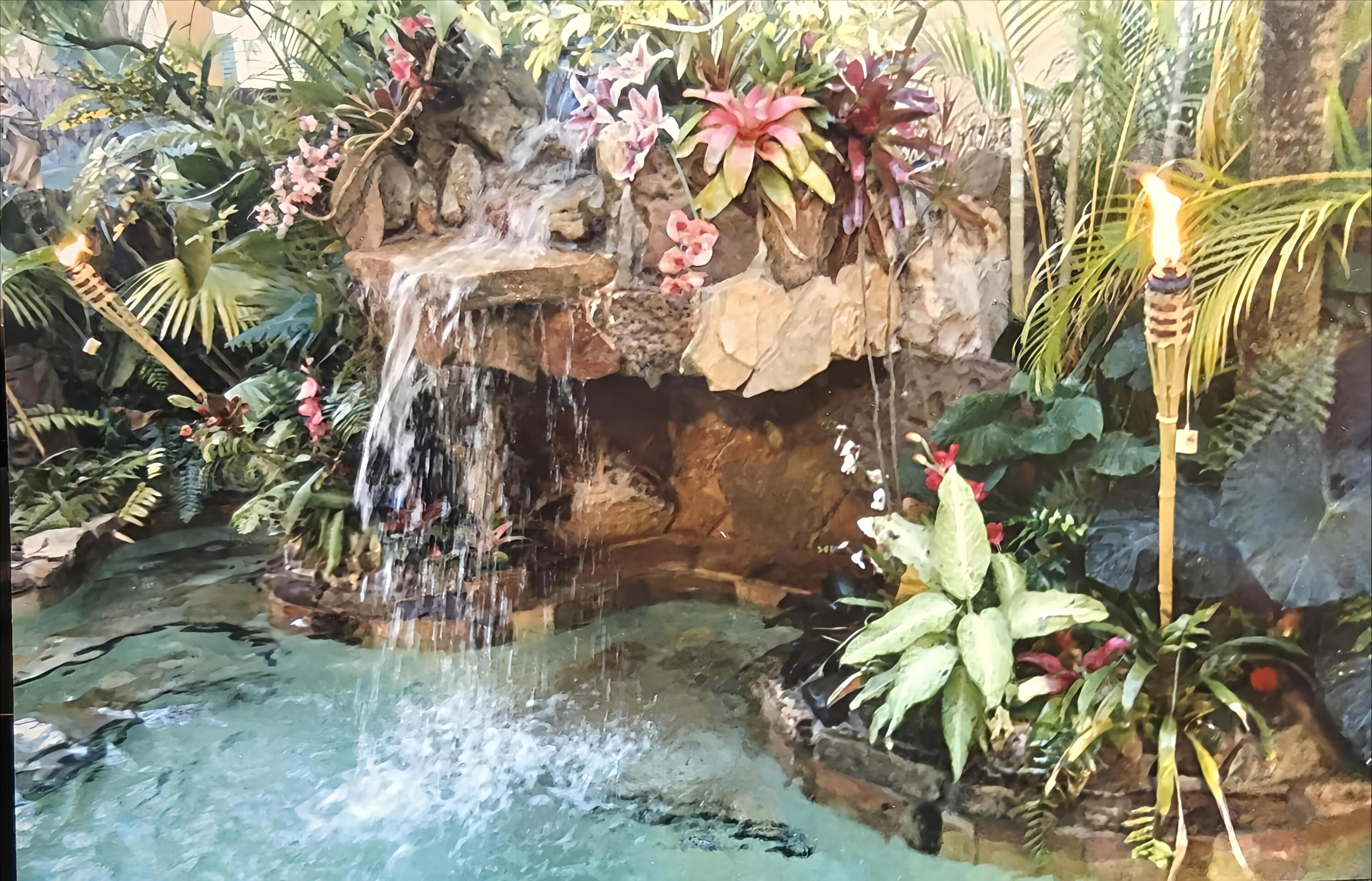 Waterfall pool led lit with tiki torches Waterfall pool led lit with tiki torches