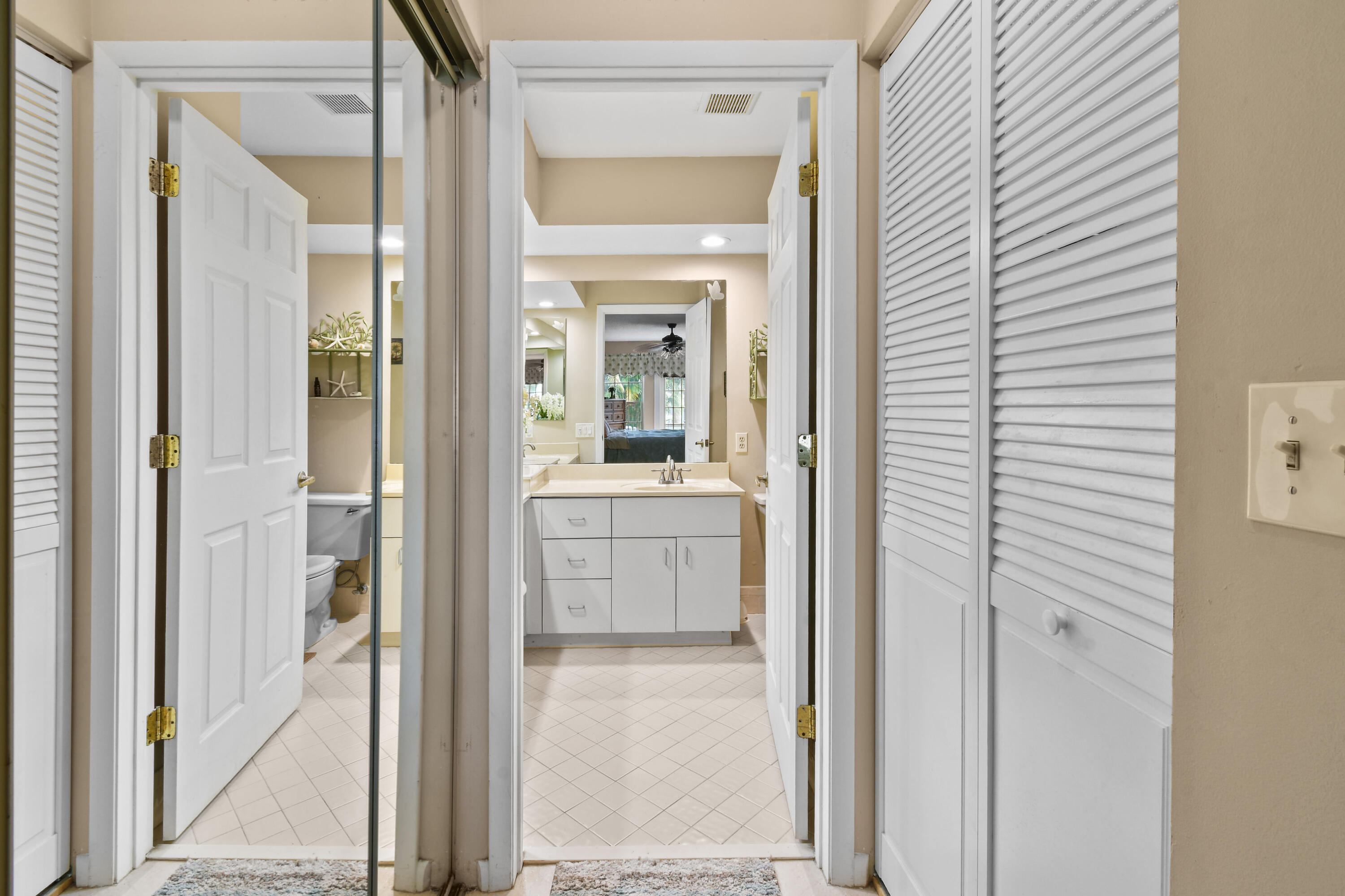 Closets on both sides of entry to primary bathroom.
