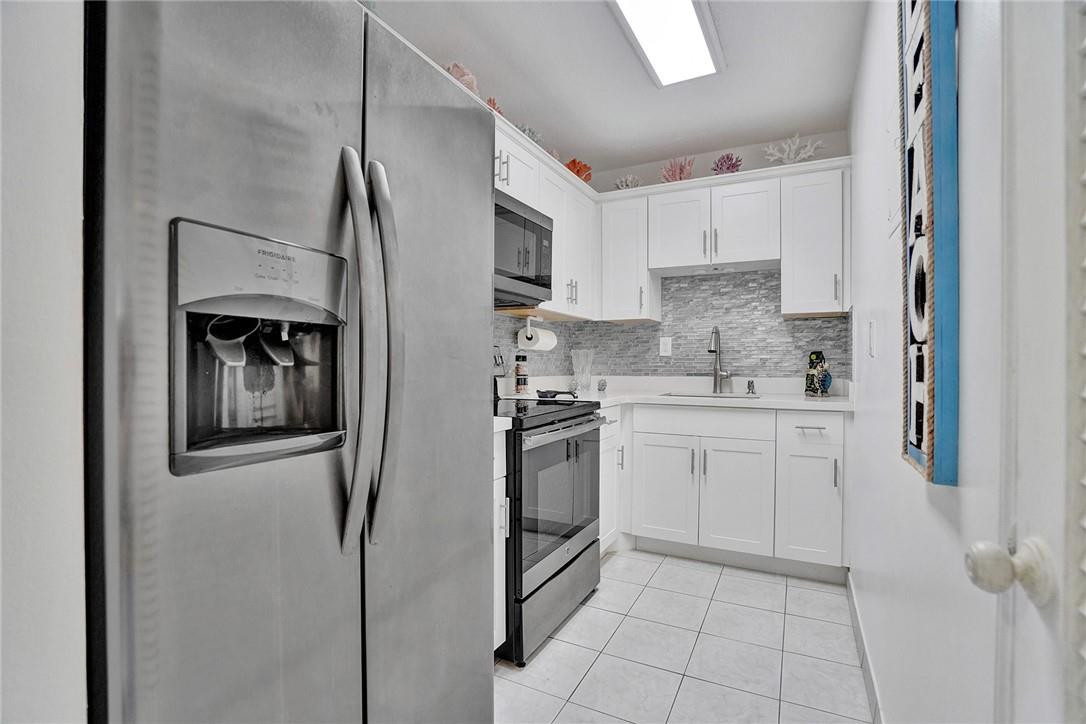 Updated Kitchen with Stainless Appliances and Glass Backsplash.