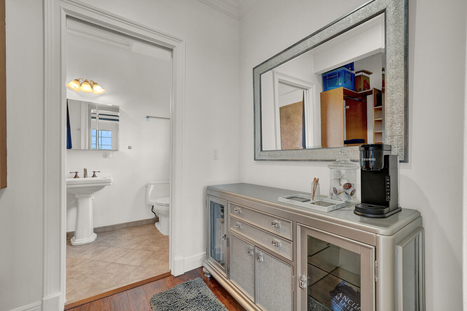 Hallway featuring wood-finish flooring, a decorative console, and a large wall mirror