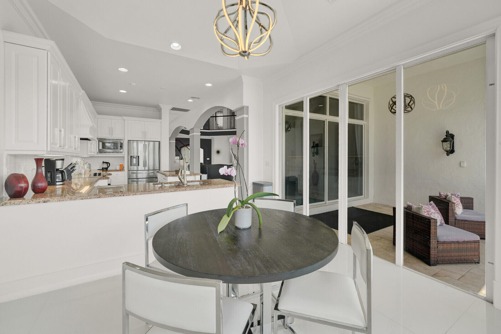 Open-concept kitchen and dining area featuring white cabinetry, light-toned countertops, and stainless steel appliances
