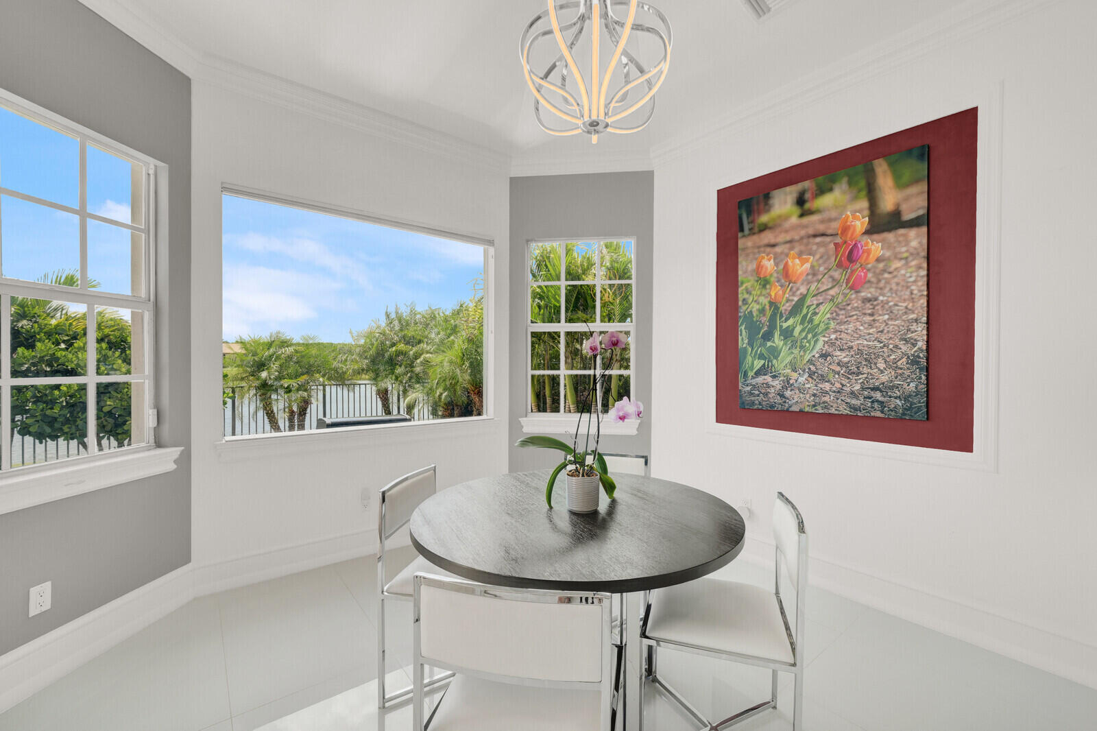 Expansive windows featuring a water view, white baseboards, and crown molding