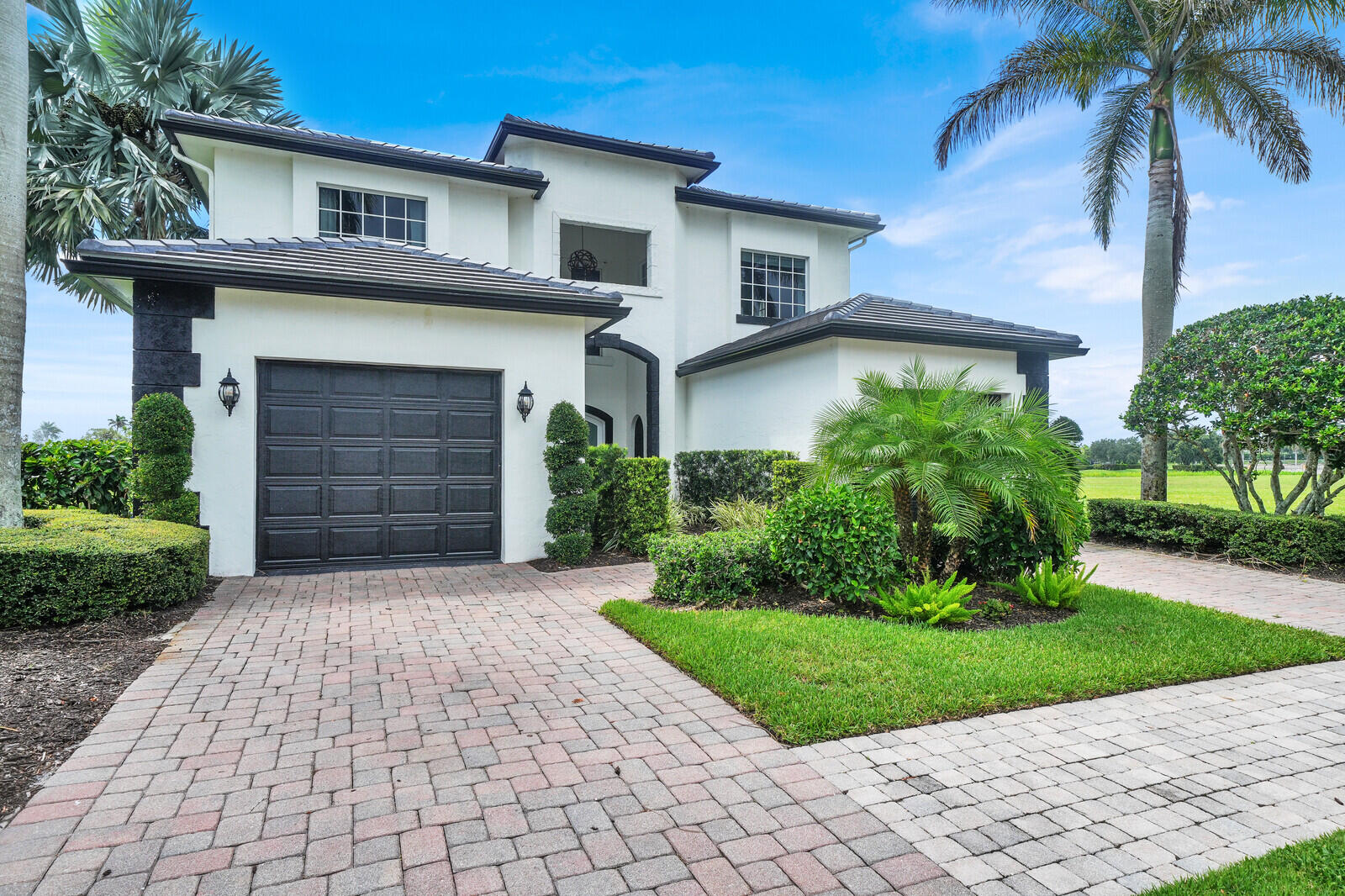 Contemporary two-story stucco exterior with a dark tile roof