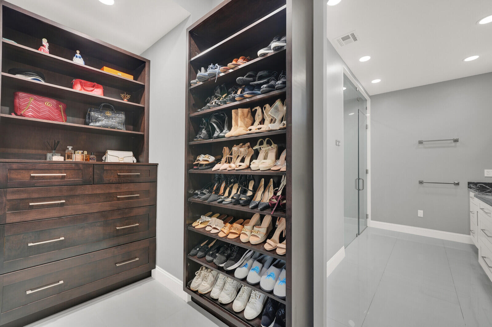 Custom dark wood cabinetry featuring extensive shelving and drawer storage
