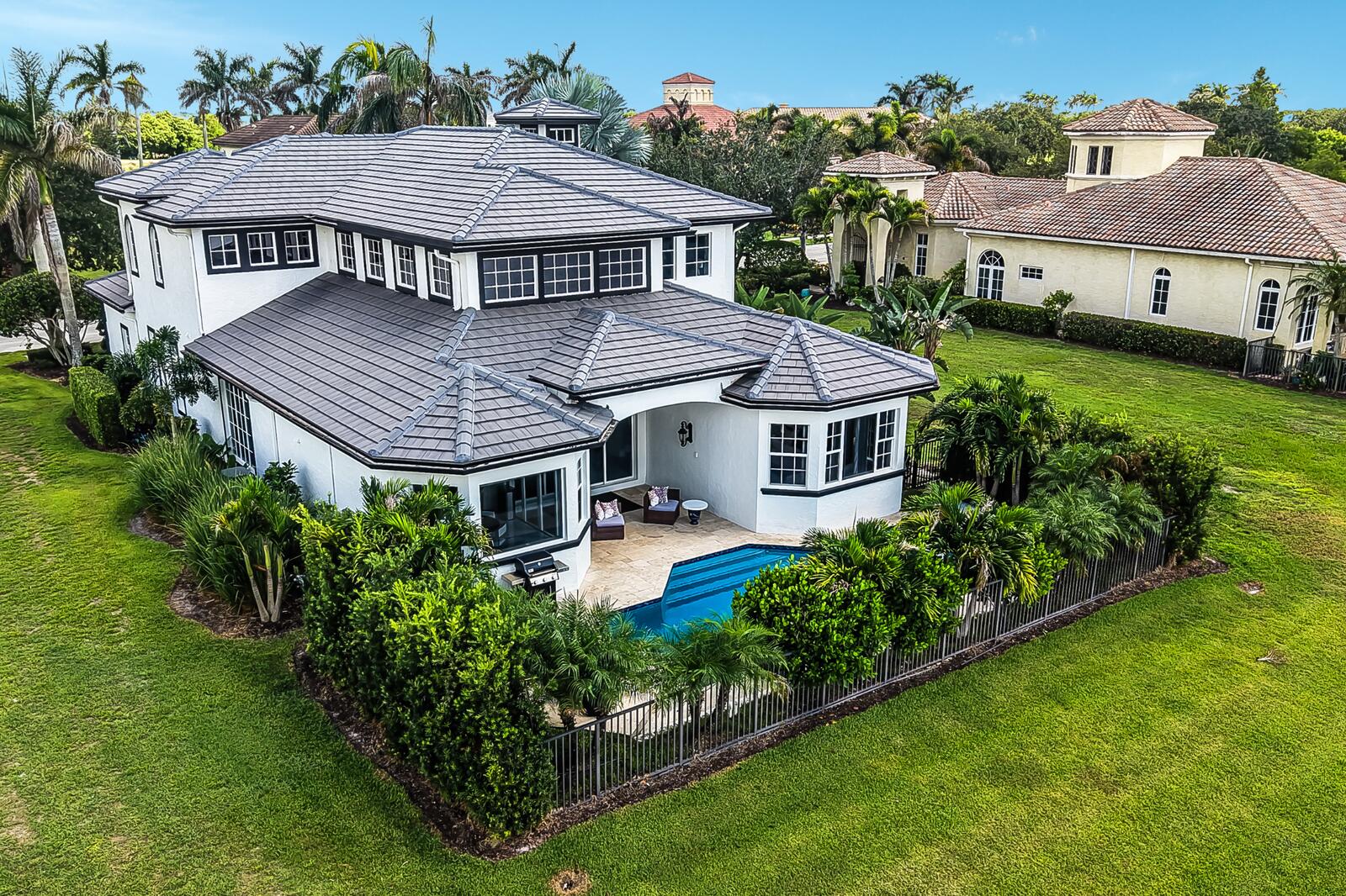 White stucco exterior with dark-framed windows and a grey tile roof