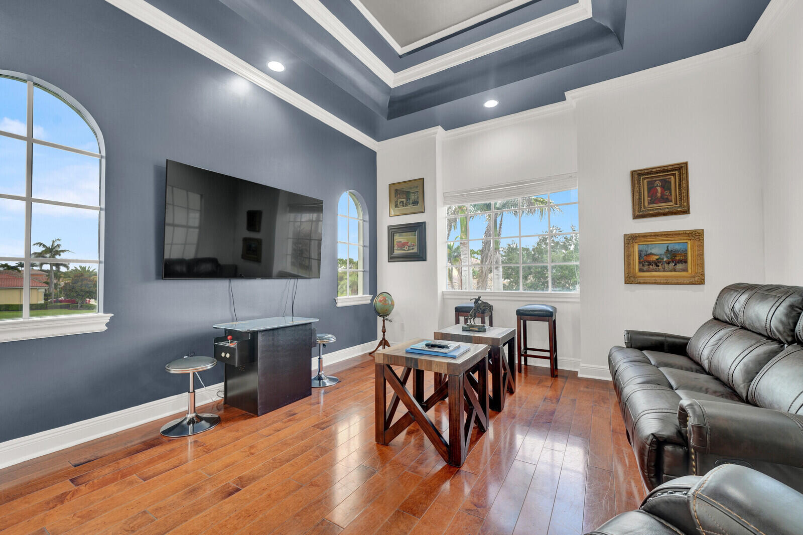 Hardwood-finish flooring complements the detailed tray ceiling with recessed lighting