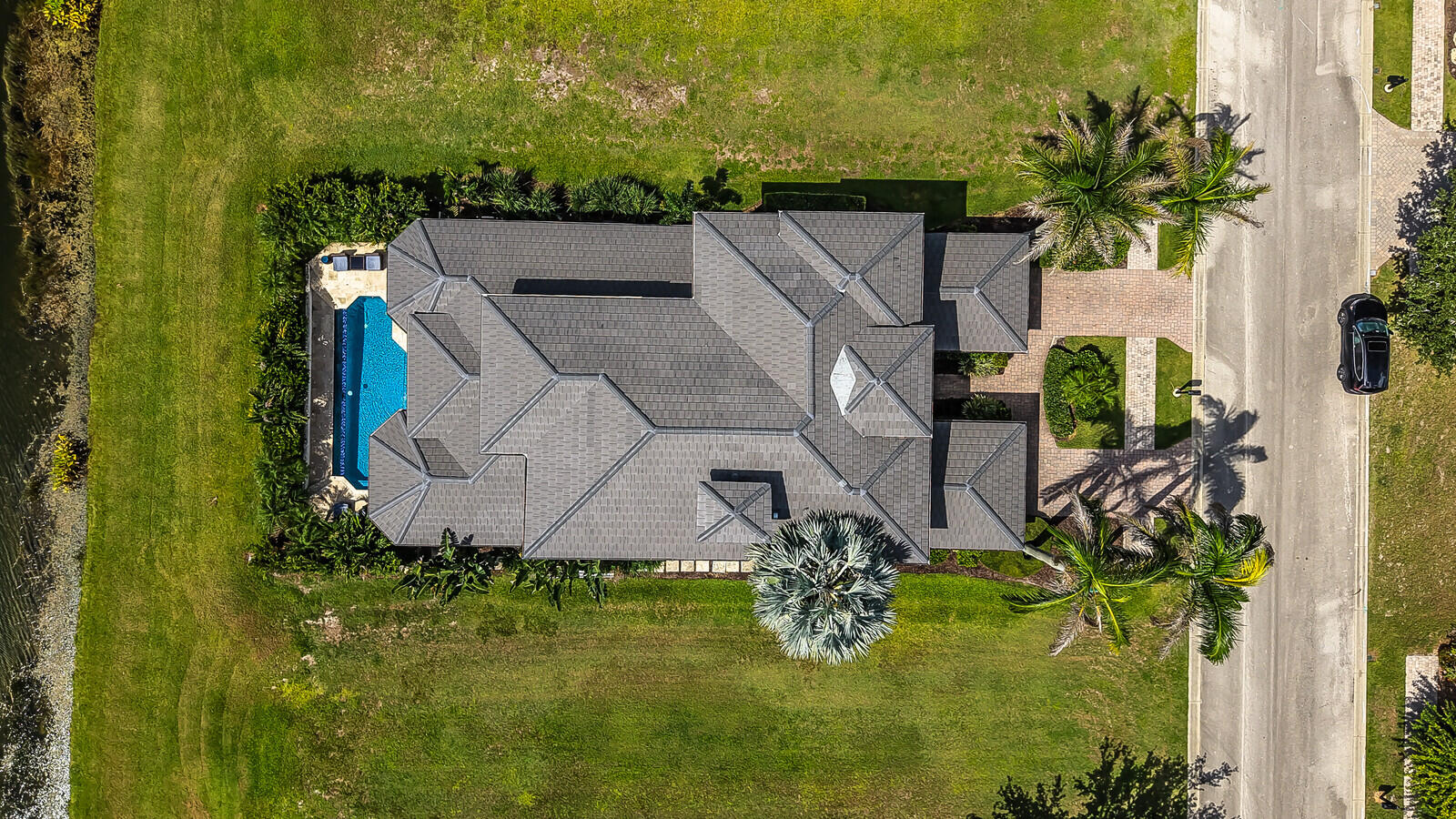 Aerial view of a property featuring a multi-gabled roofline and an expansive outdoor pool area