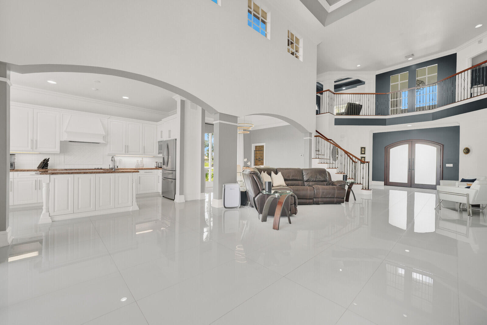 Two-story foyer with a grand staircase and wrought iron balusters