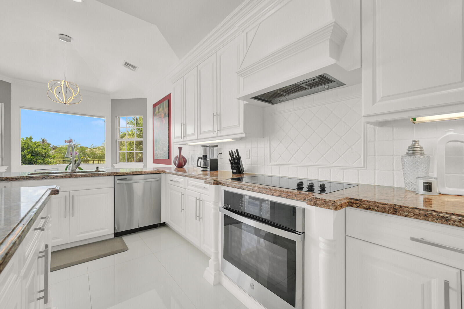 Kitchen featuring white cabinetry, brown granite countertops, a built-in oven, and a built-in electric cooktop