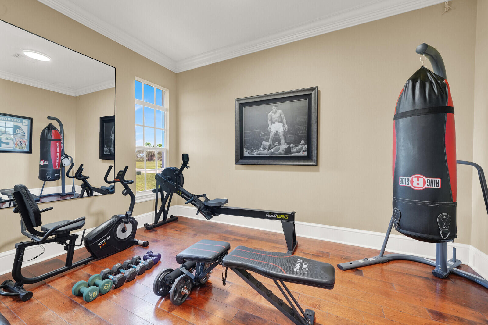Dedicated room featuring wood-finish flooring, a large window, and crown molding
