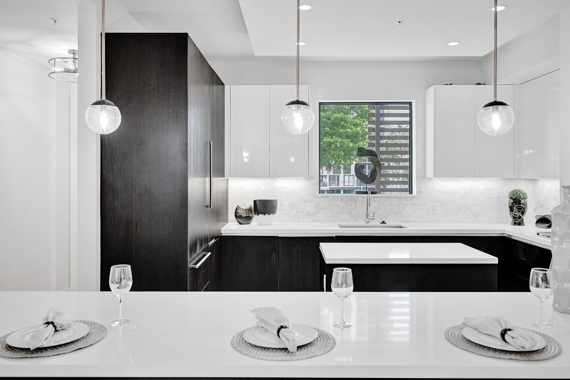 Modern kitchen featuring white countertops, two-tone cabinetry, and a white tile backsplash