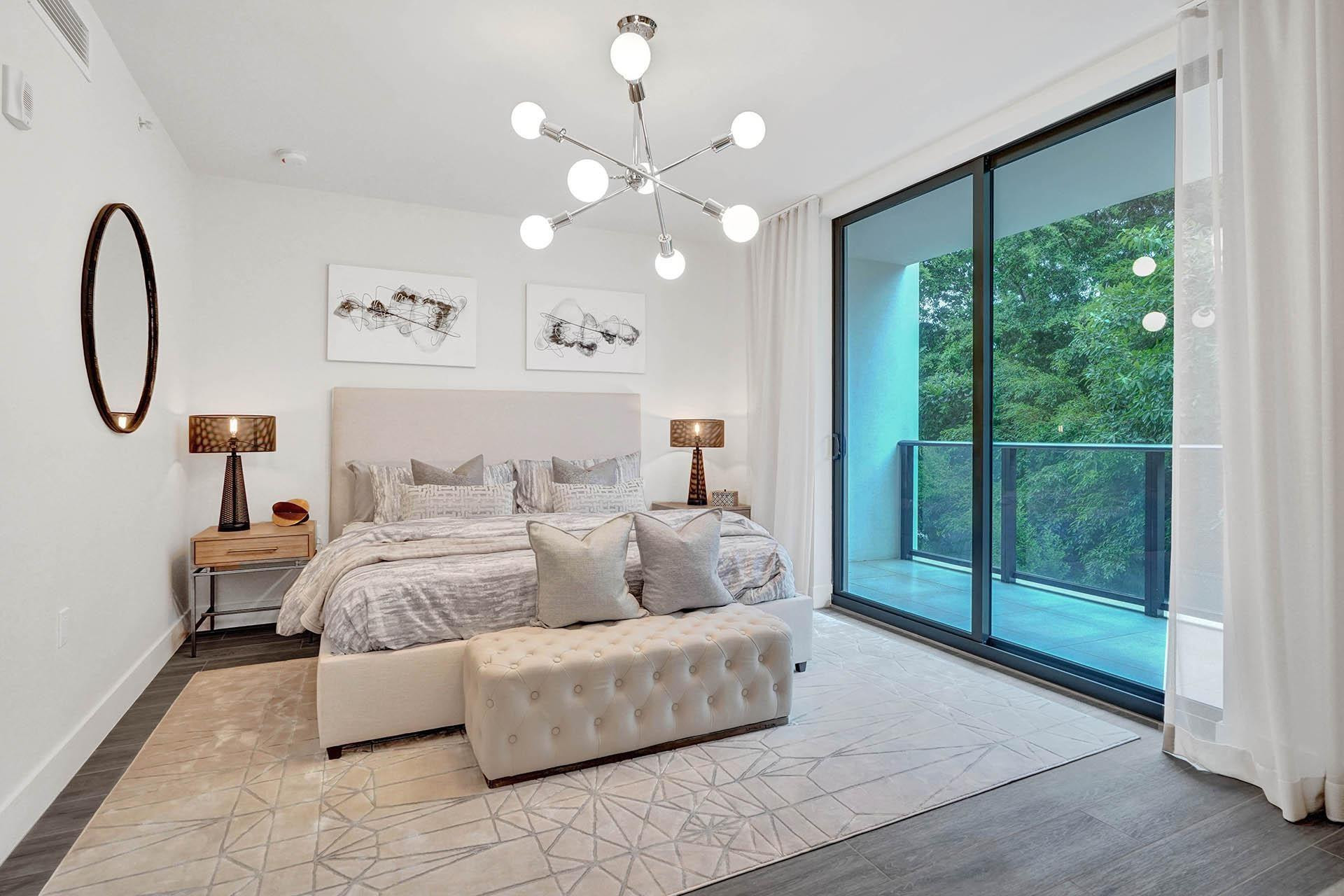 Sliding glass doors opening to a private balcony with glass railings