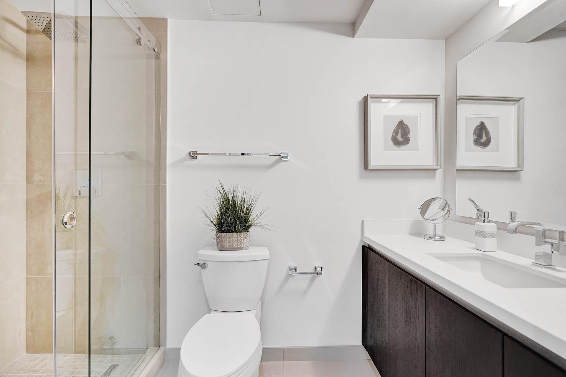 Contemporary bathroom featuring a floating double-sink vanity with white quartz countertop and brushed nickel fixtures, paired with dark wood cabinetry