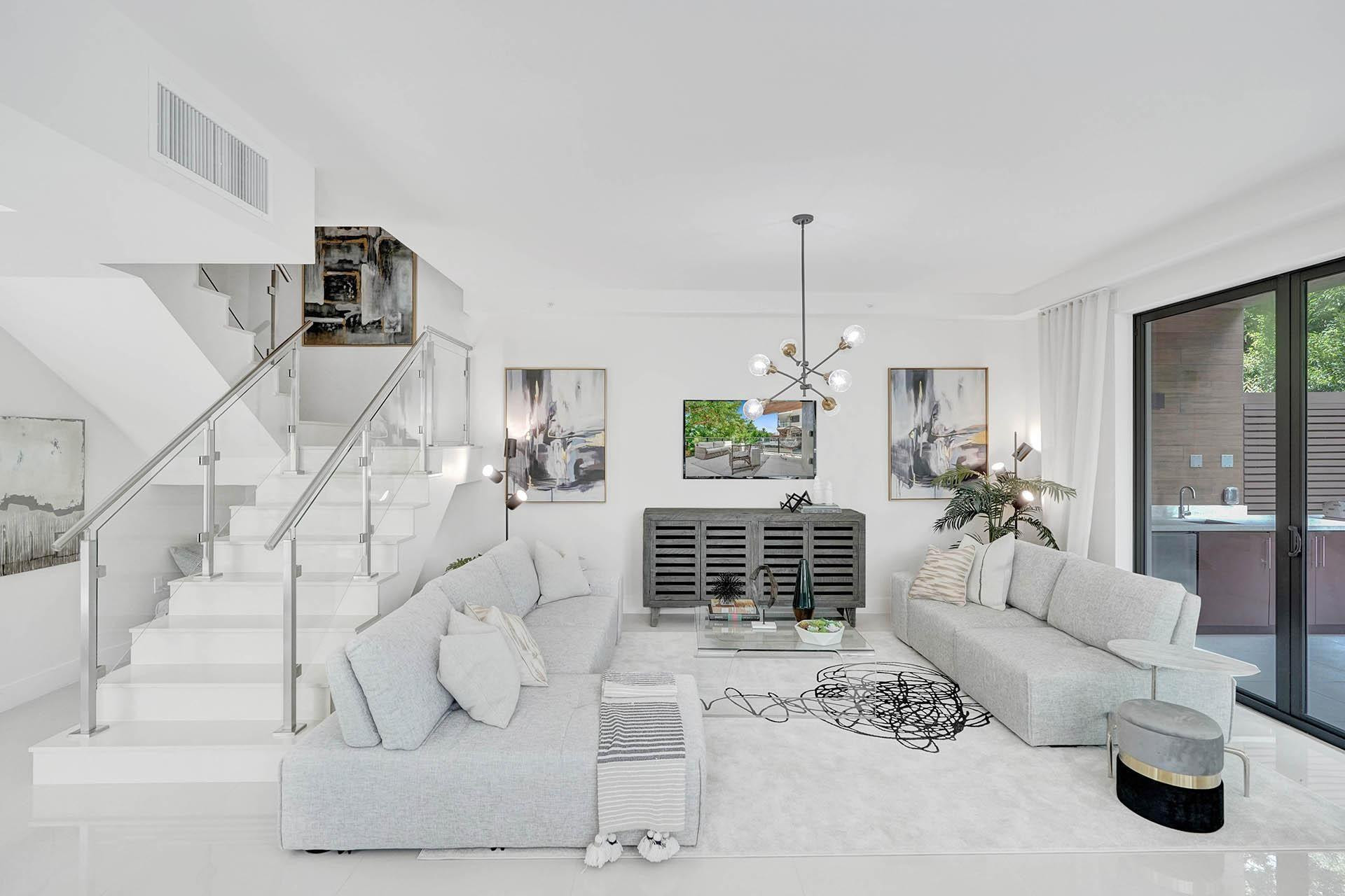 Contemporary living area featuring bright white walls and polished tile flooring