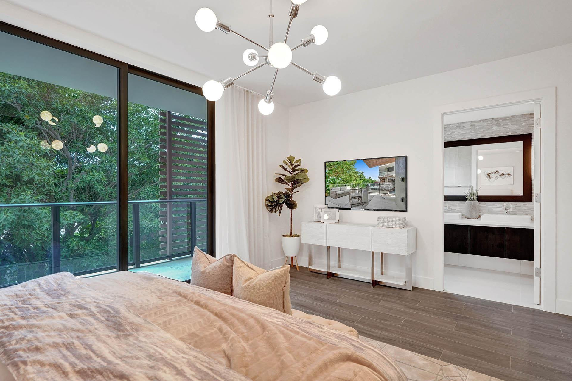 Spacious room featuring floor-to-ceiling sliding glass doors opening to a balcony with a glass railing
