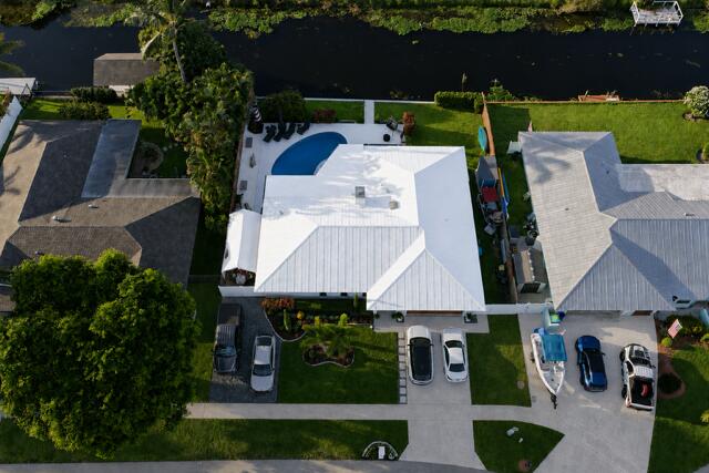 This impressive aerial view showcases the home's beautifully landscaped curb appeal, two driveways, and friendly neighbors.