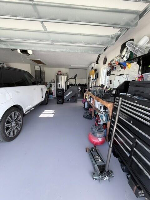 This Air conditioned garage features a dedicated workstation and ample room for tolls, storage, and everyday projects. A convenient laundry area with washer and dryer adding functi9onality while keeping household tasks organized and easily accessible.