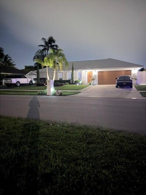 Beautifully illuminated at night, this inviting home showcases exceptional curb appeal with lush topical landscaping and a war, welcoming entrance. Elegant exterior lighting highlights the home's architecture and creates a striking first impression after sunset.