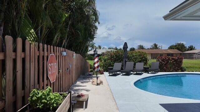 This resort-style pool area brings a touch of the beach home with its sandy retreat, tropical landscaping, and inviting lounger space. It creates a private coastal-inspired oasis right in your own backyard.
