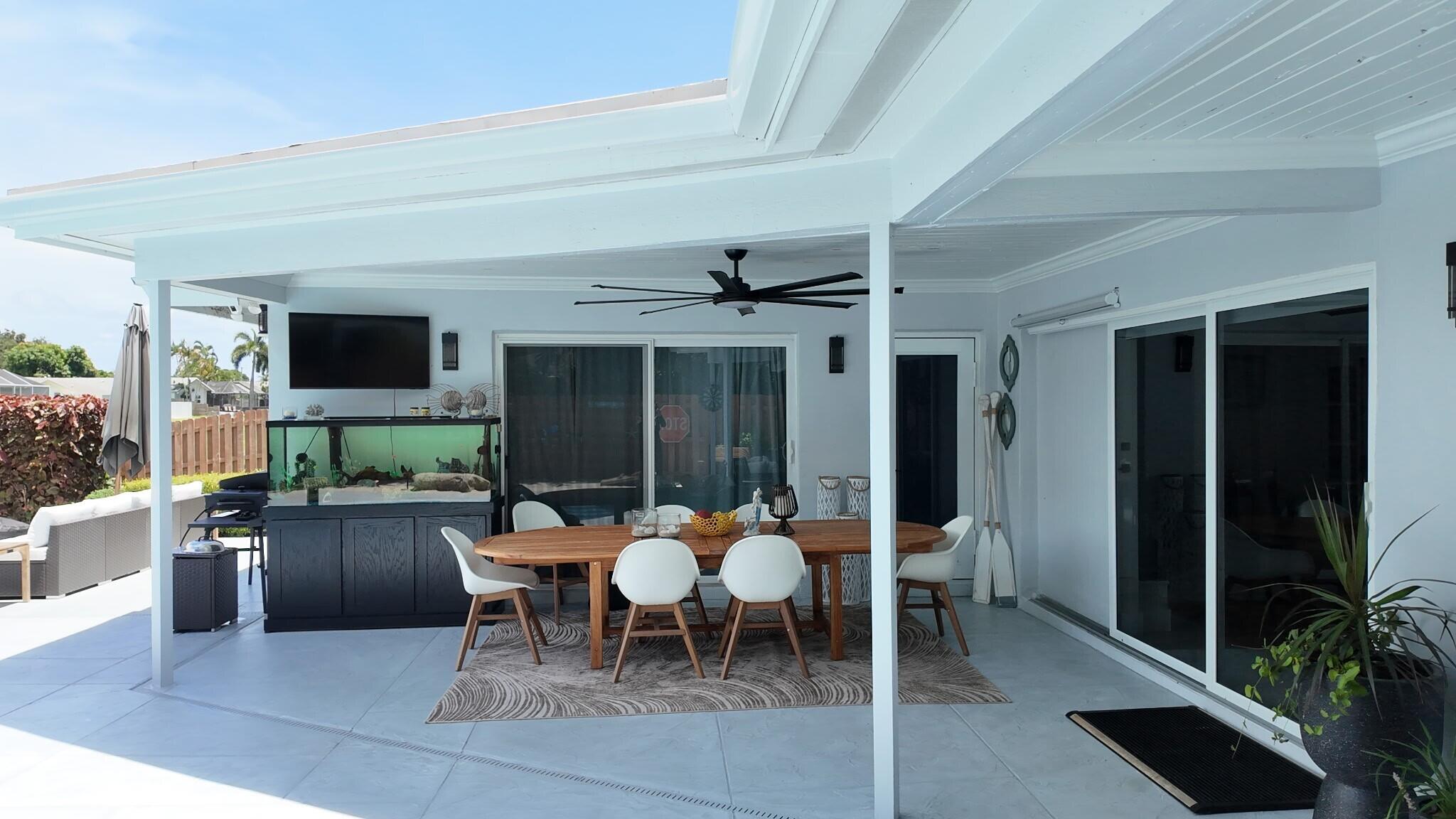 This spacious covered patio area offers the perfect setting for outdoor dining and entertaining while overlooking the peaceful waterfront canal.