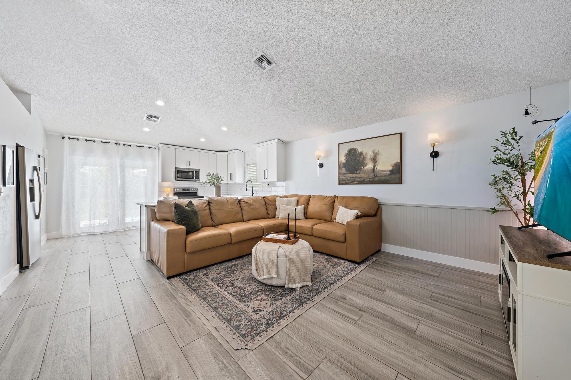 Light wood-finish flooring, white paneled lower wall, white upper walls, recessed lighting, and built-in white cabinetry