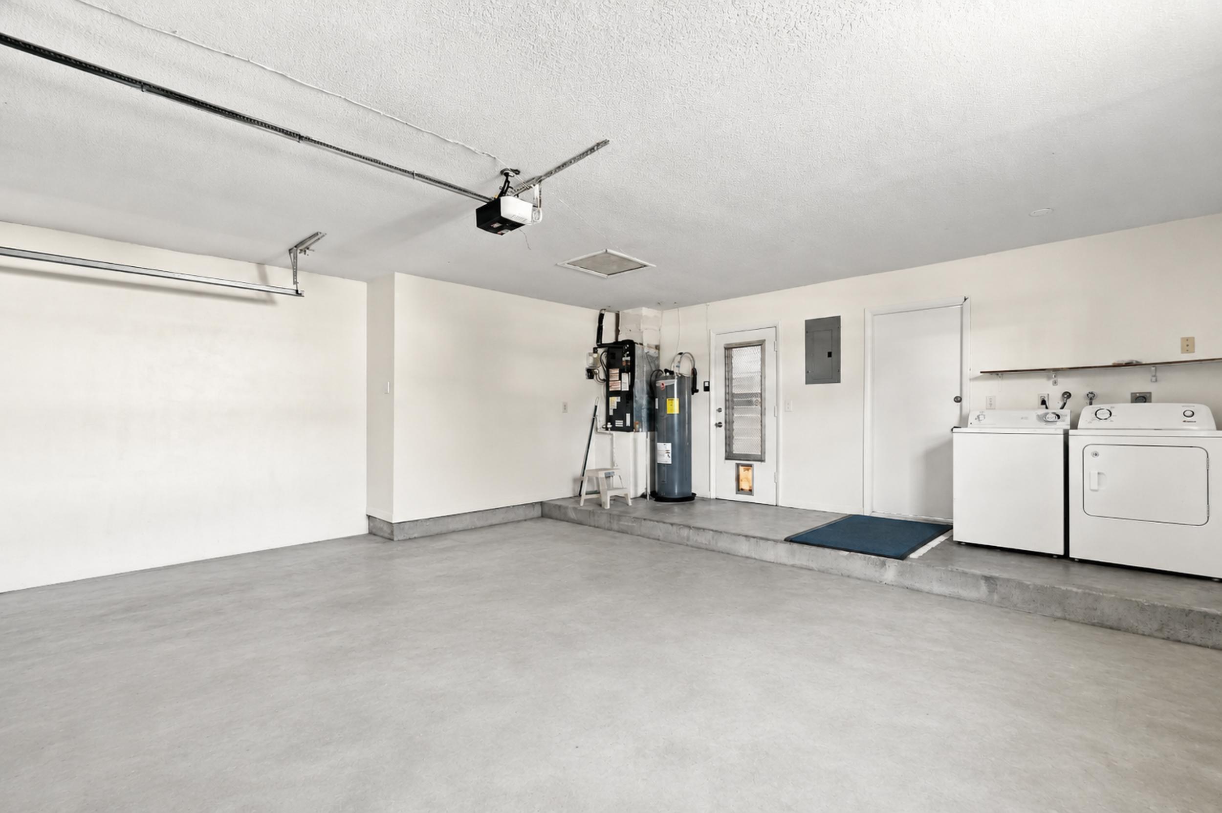Spacious garage with utility area and room for parking and storage.