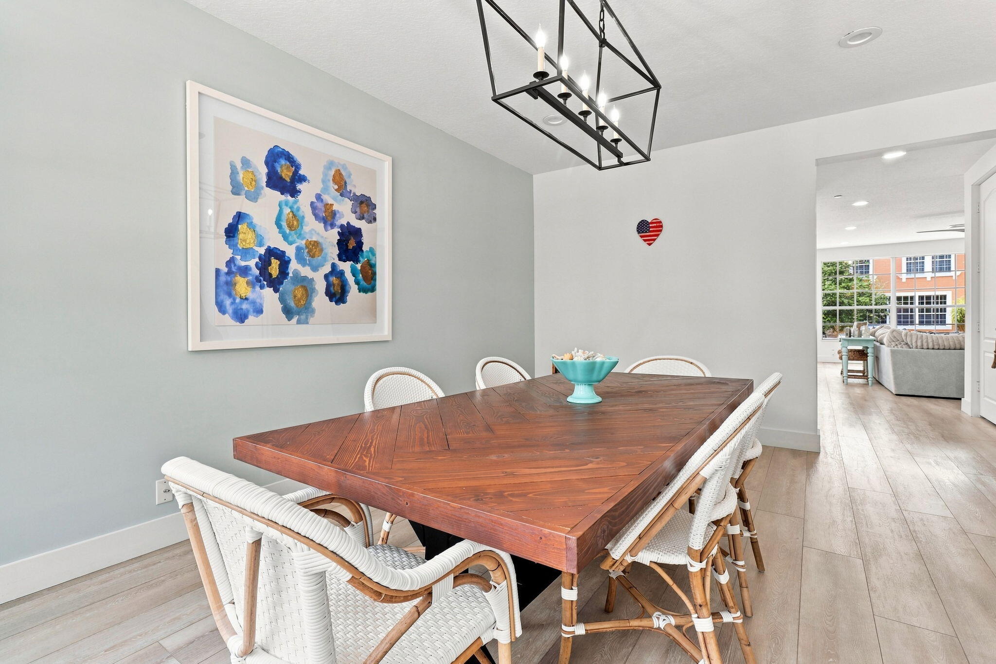 Open dining area with luxury vinyl flooring and a linear chandelier
