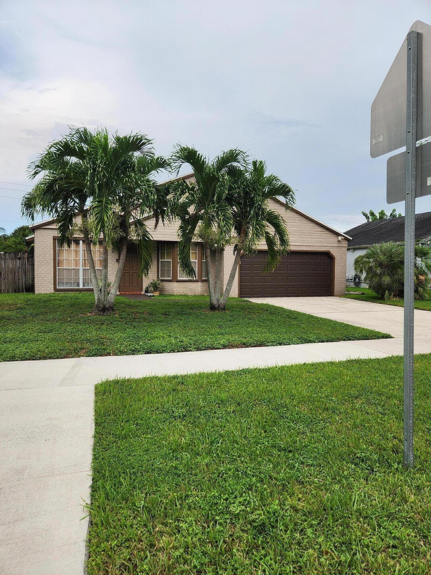 Single-story residence featuring a brick facade, attached garage, and concrete driveway
