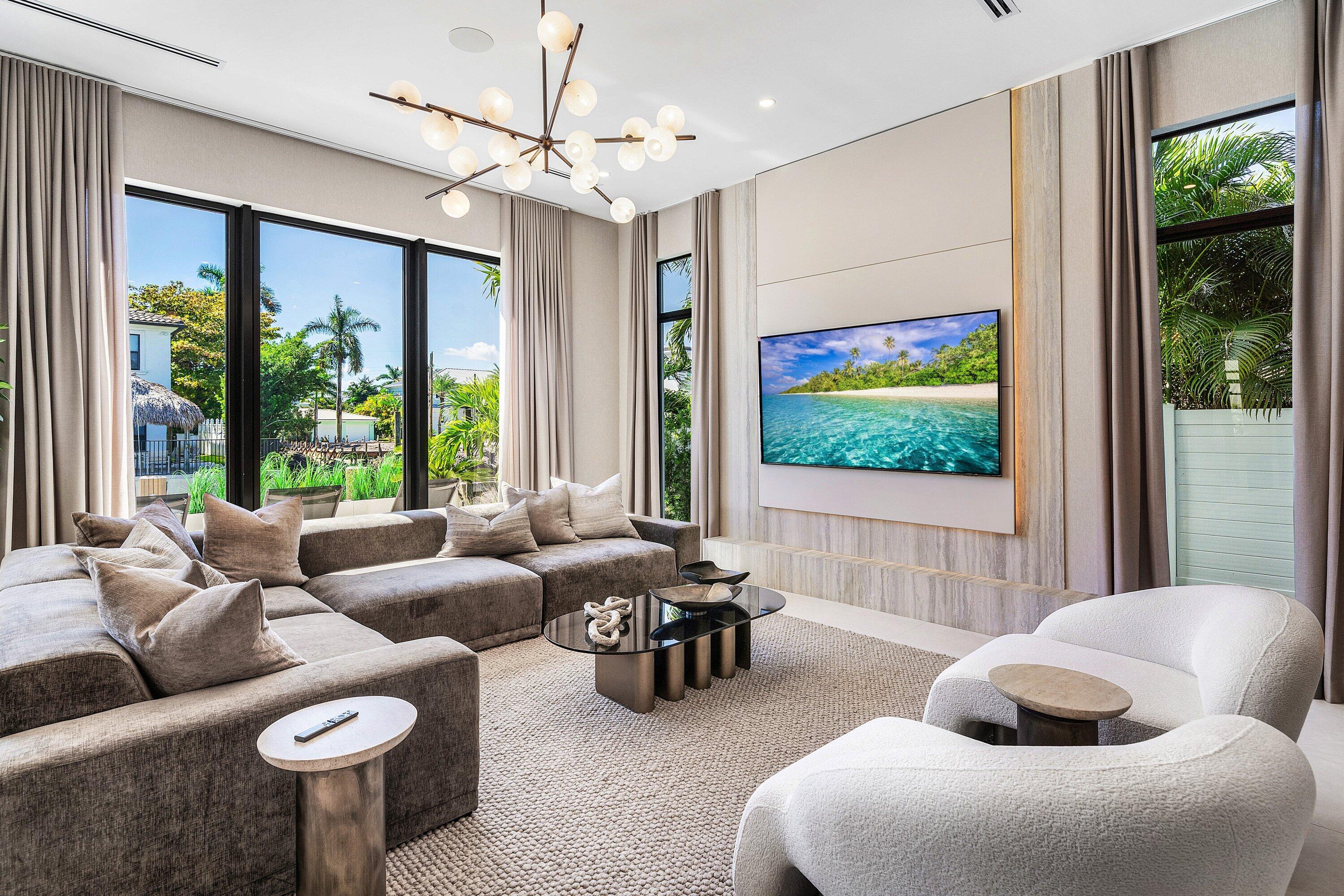 Integrated media wall with built-in cabinetry, large format television, and accent lighting