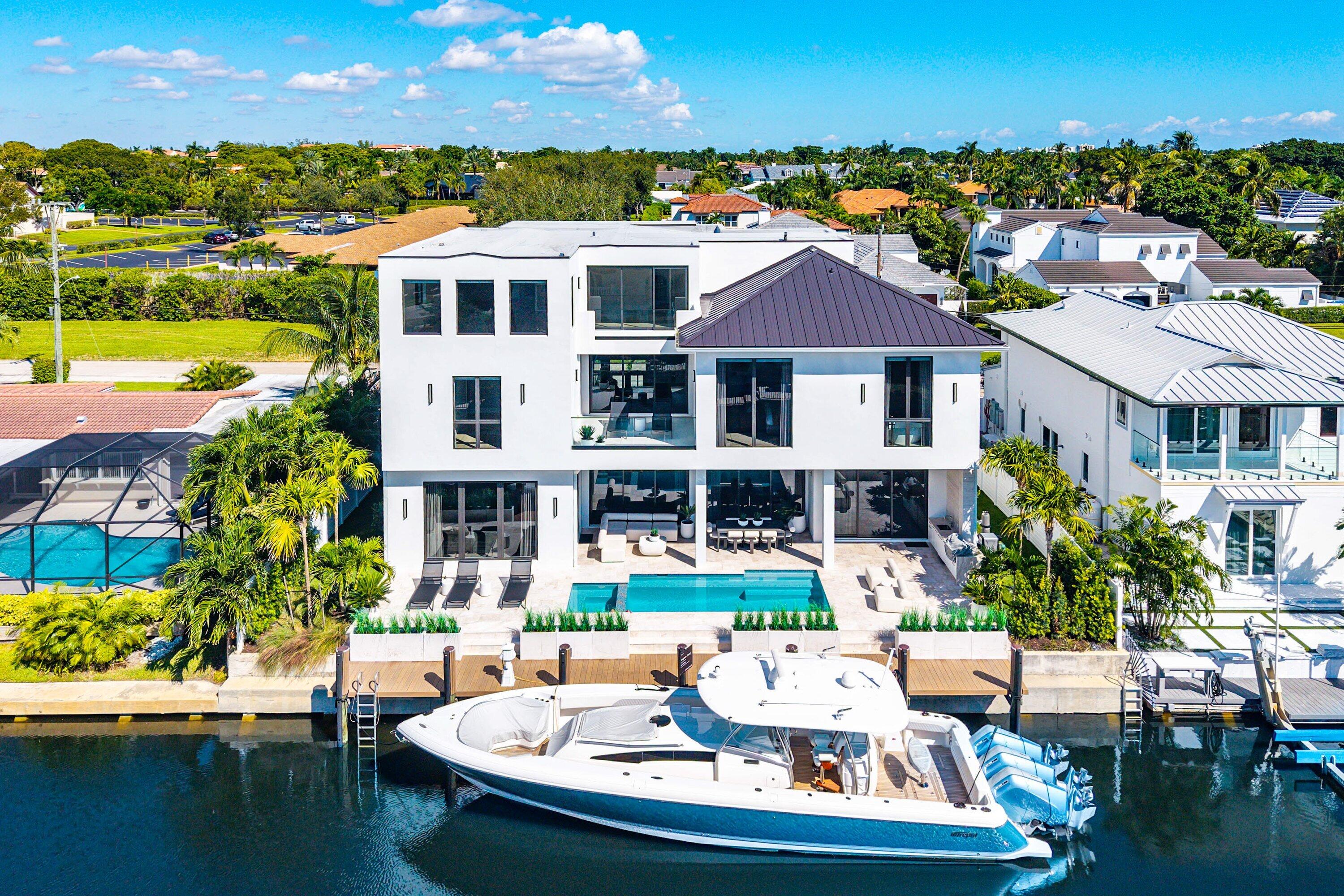 Modern architectural design with multiple balconies, a private pool, and direct water access