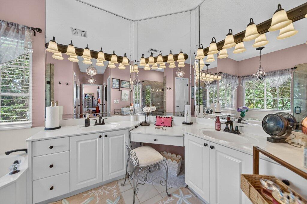 Dual white vanities with integrated sinks, white countertops, and white cabinetry