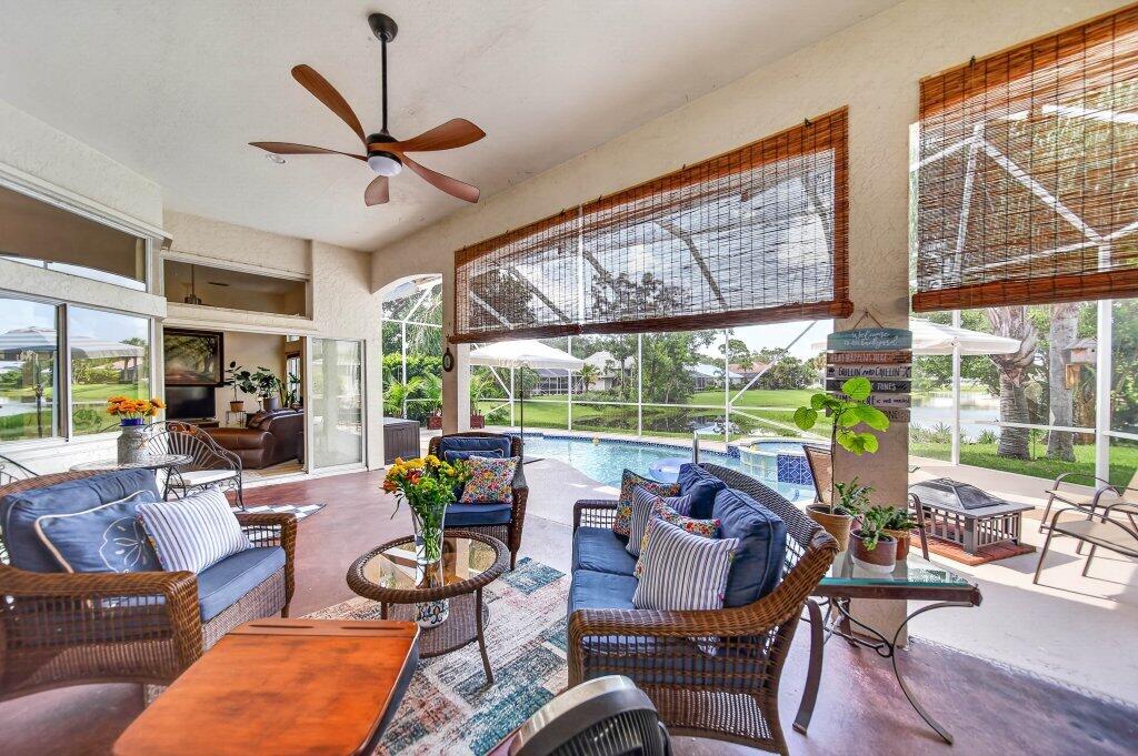 Expansive screened-in lanai with a vaulted ceiling and ceiling fan, featuring a private swimming pool and integrated spa