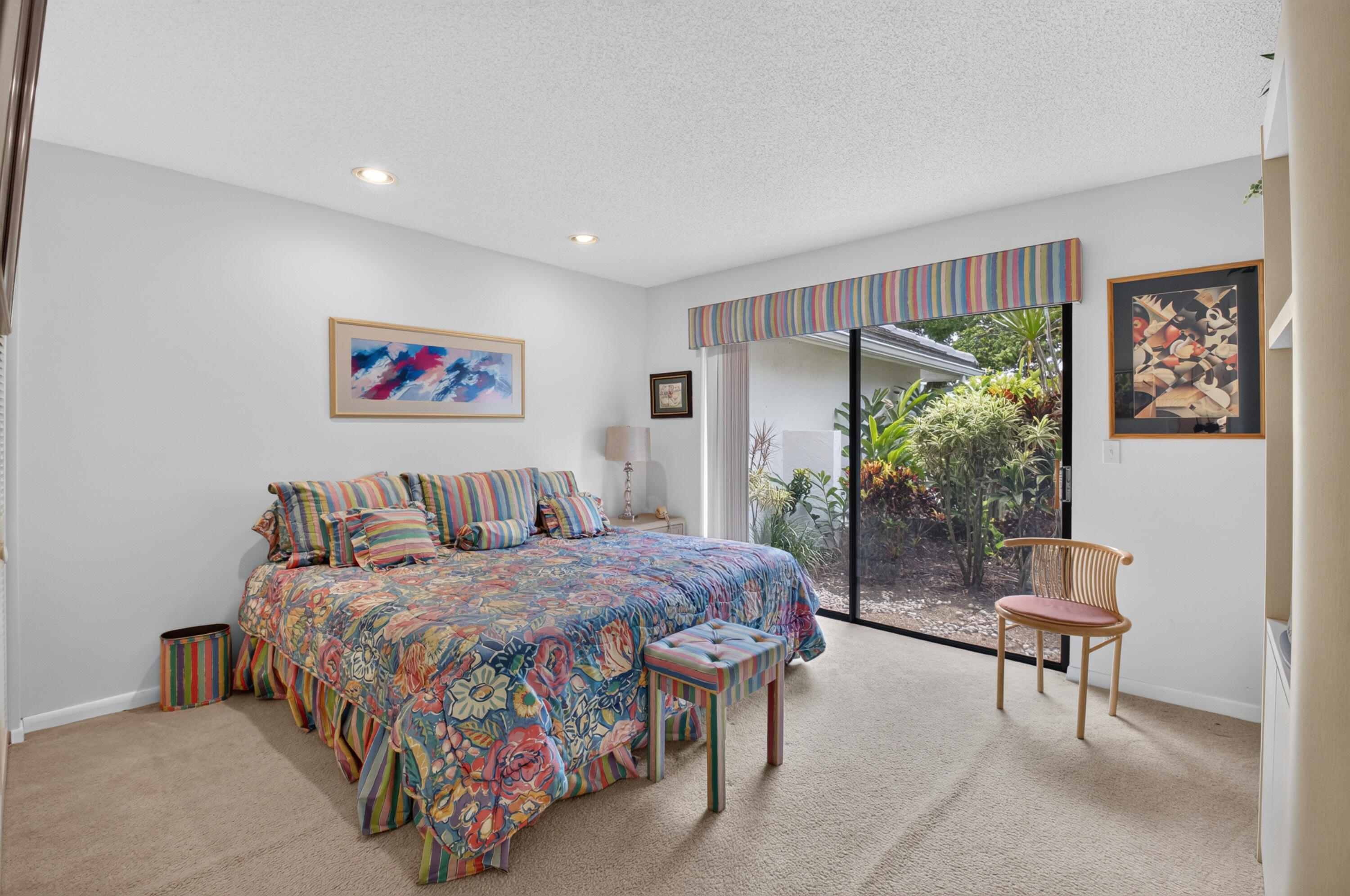 Recessed lighting, sliding glass door, outdoor landscaping, built-in shelving, and carpeted flooring