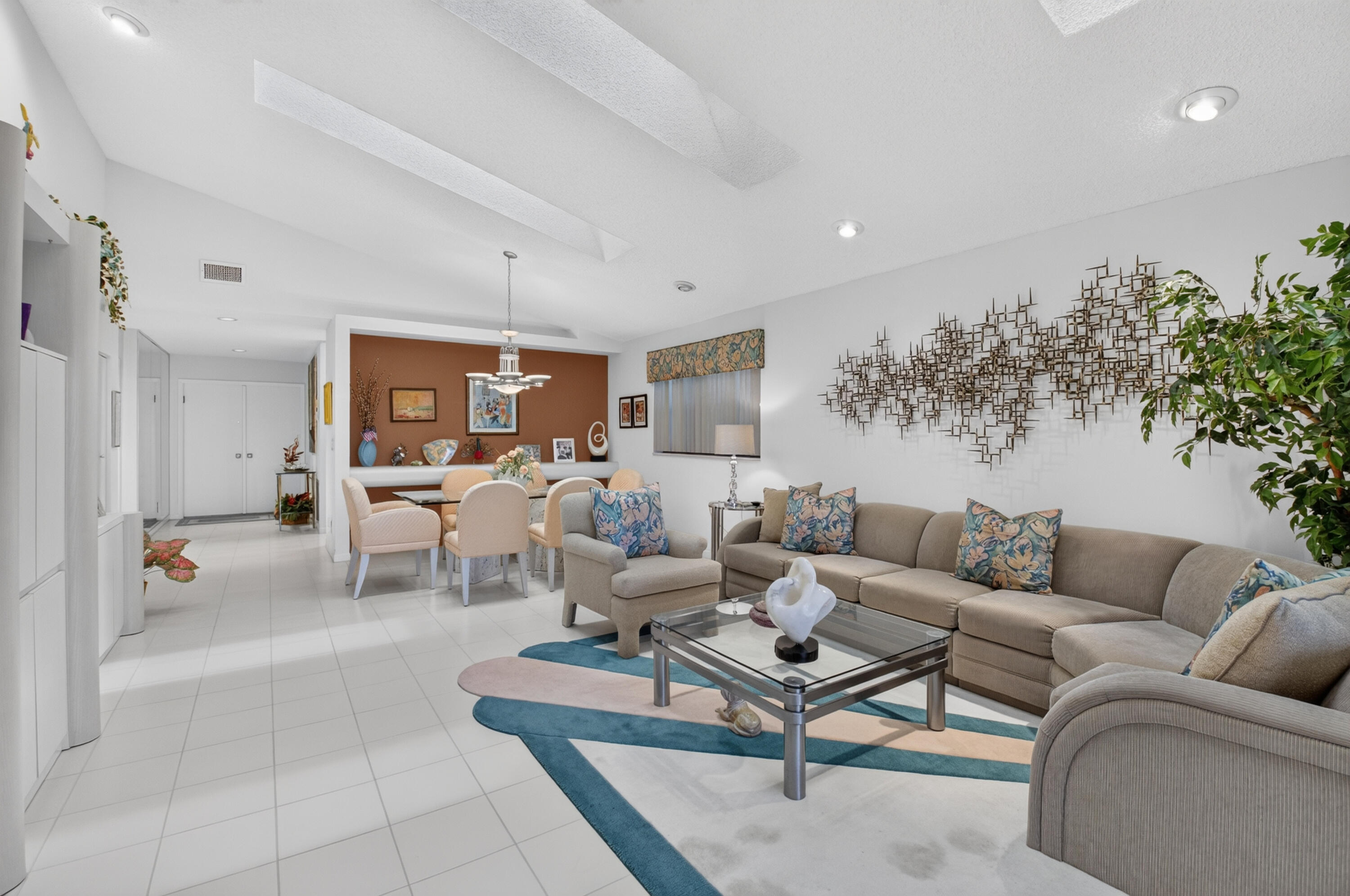 Vaulted ceilings with recessed lighting, tile flooring, built-in cabinetry, and a dining area with a chandelier