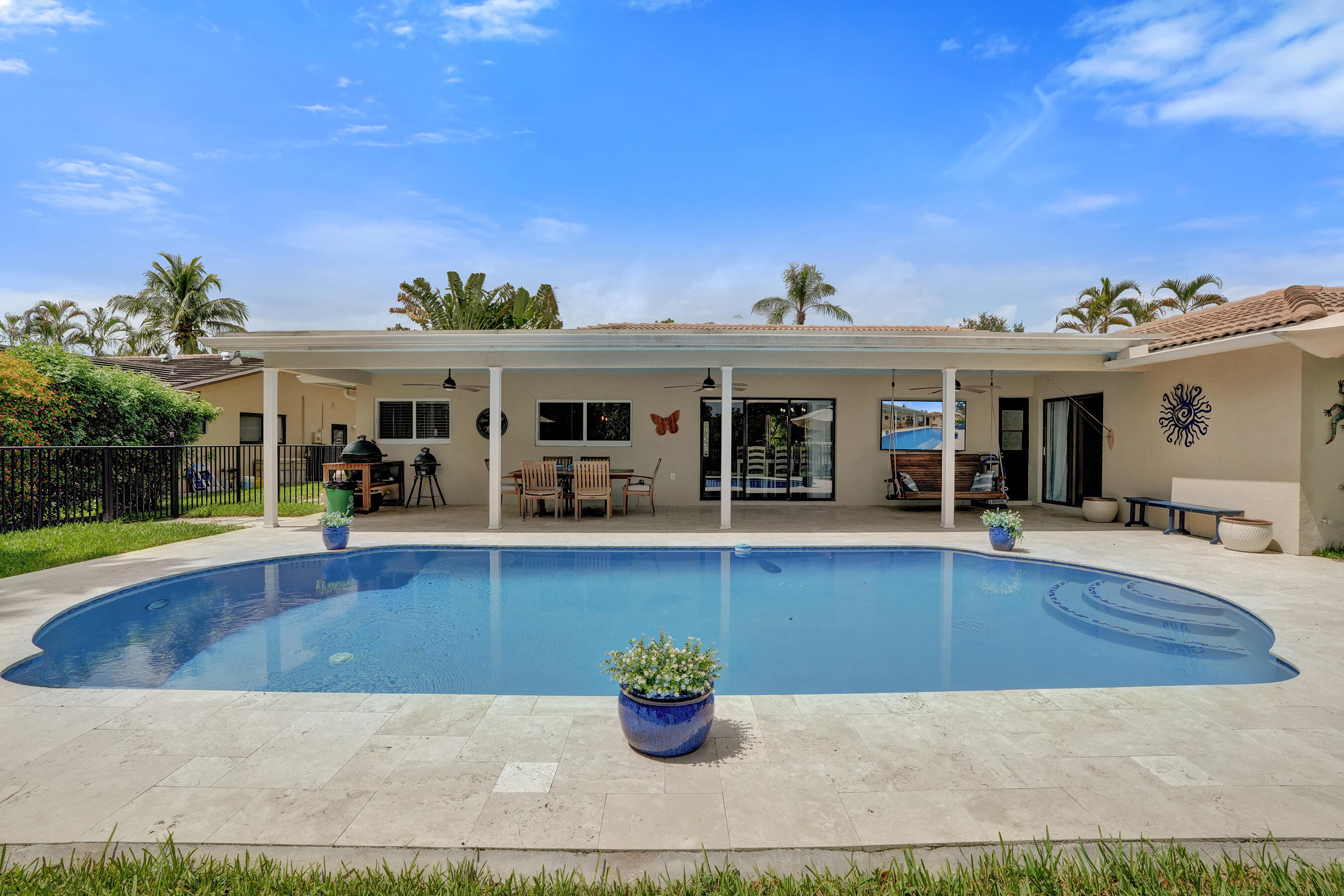 Covered patio offering multiple sitting areas with travertine tile