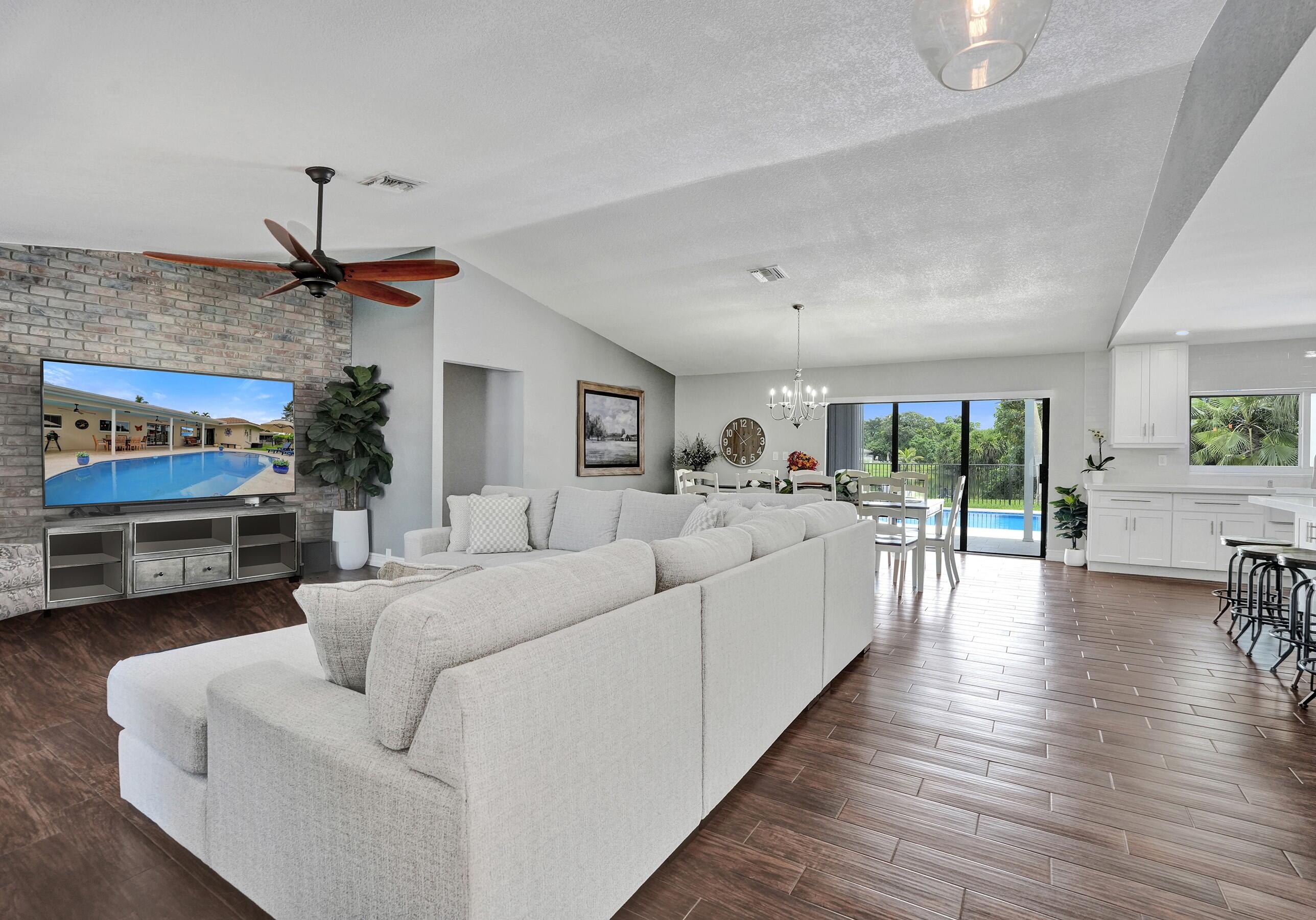 View from front door- living room, dining, kitchen and pool