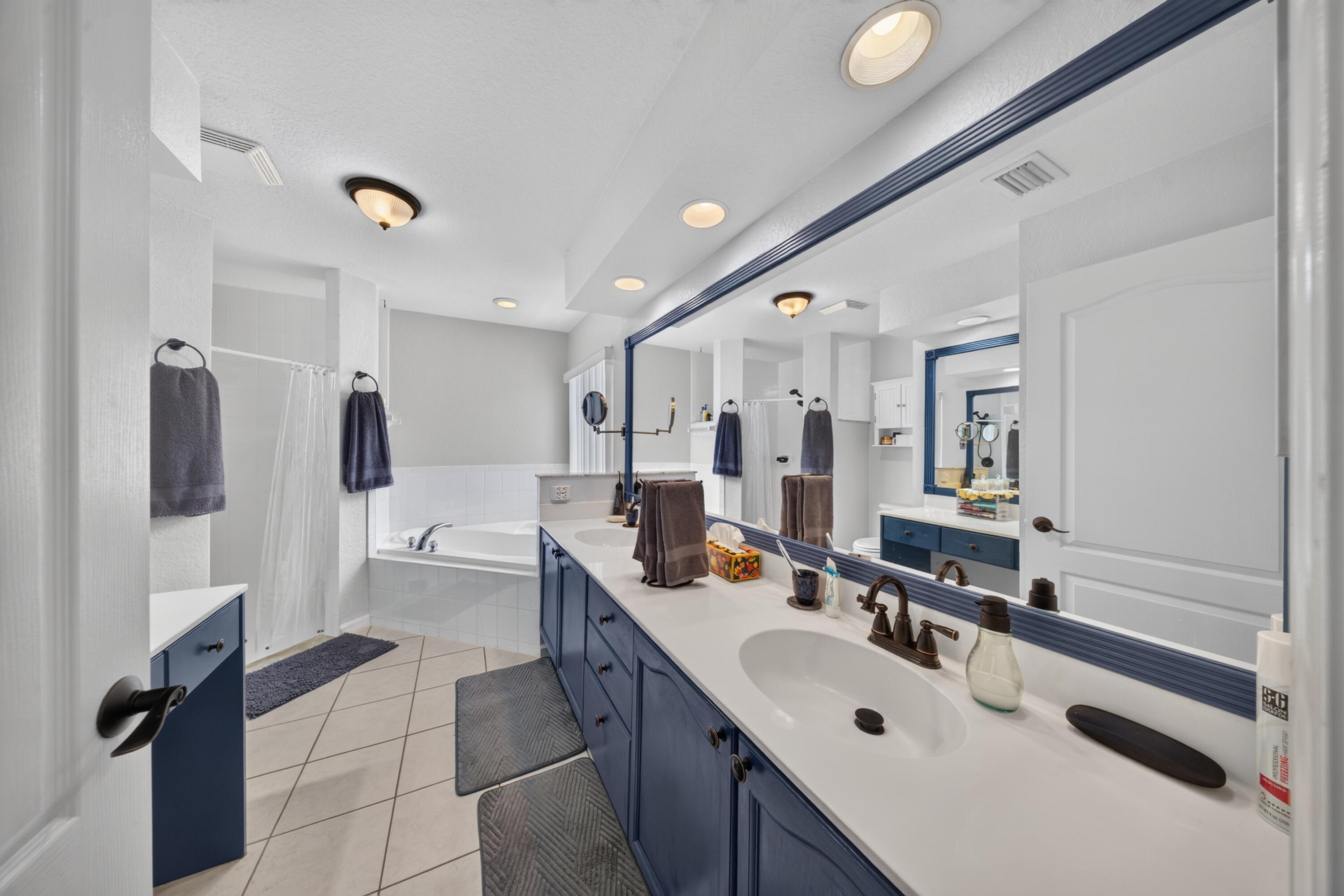 Dual vanity with white countertops and dark cabinetry