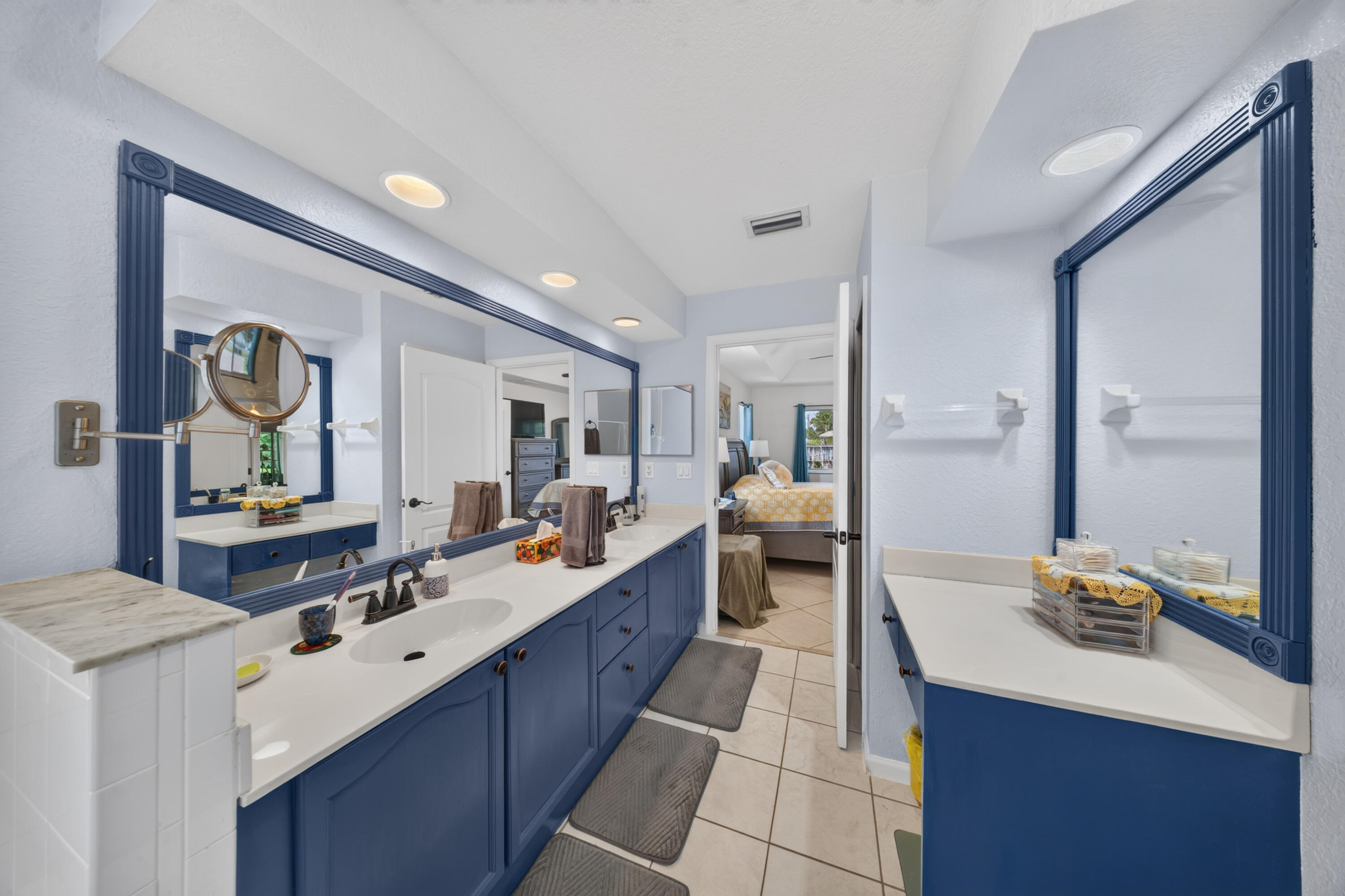 Dual vanity with undermount sinks, white countertops, and blue base cabinetry