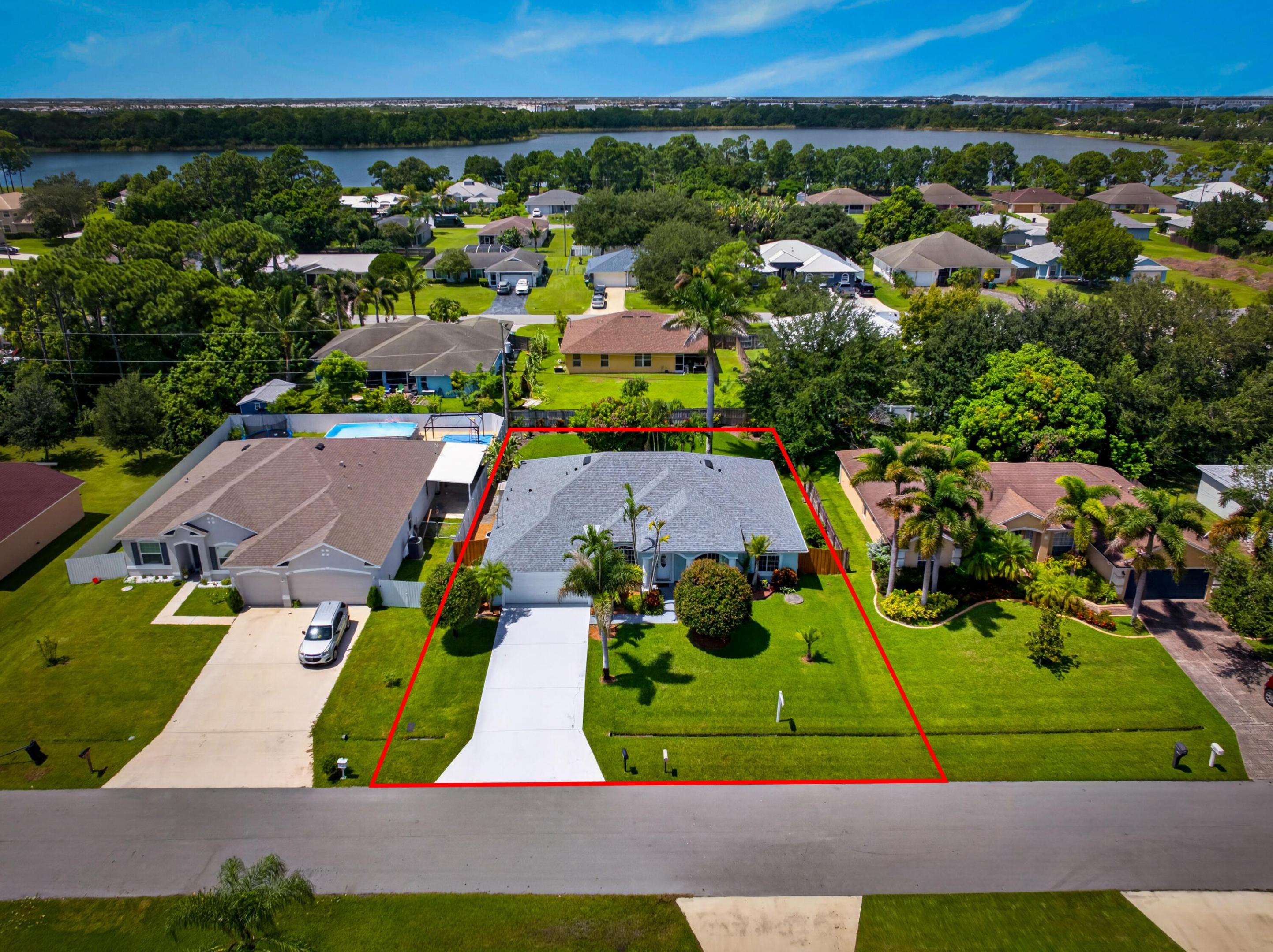 Single-story residential structure with a light-colored roof, front lawn, and paved driveway