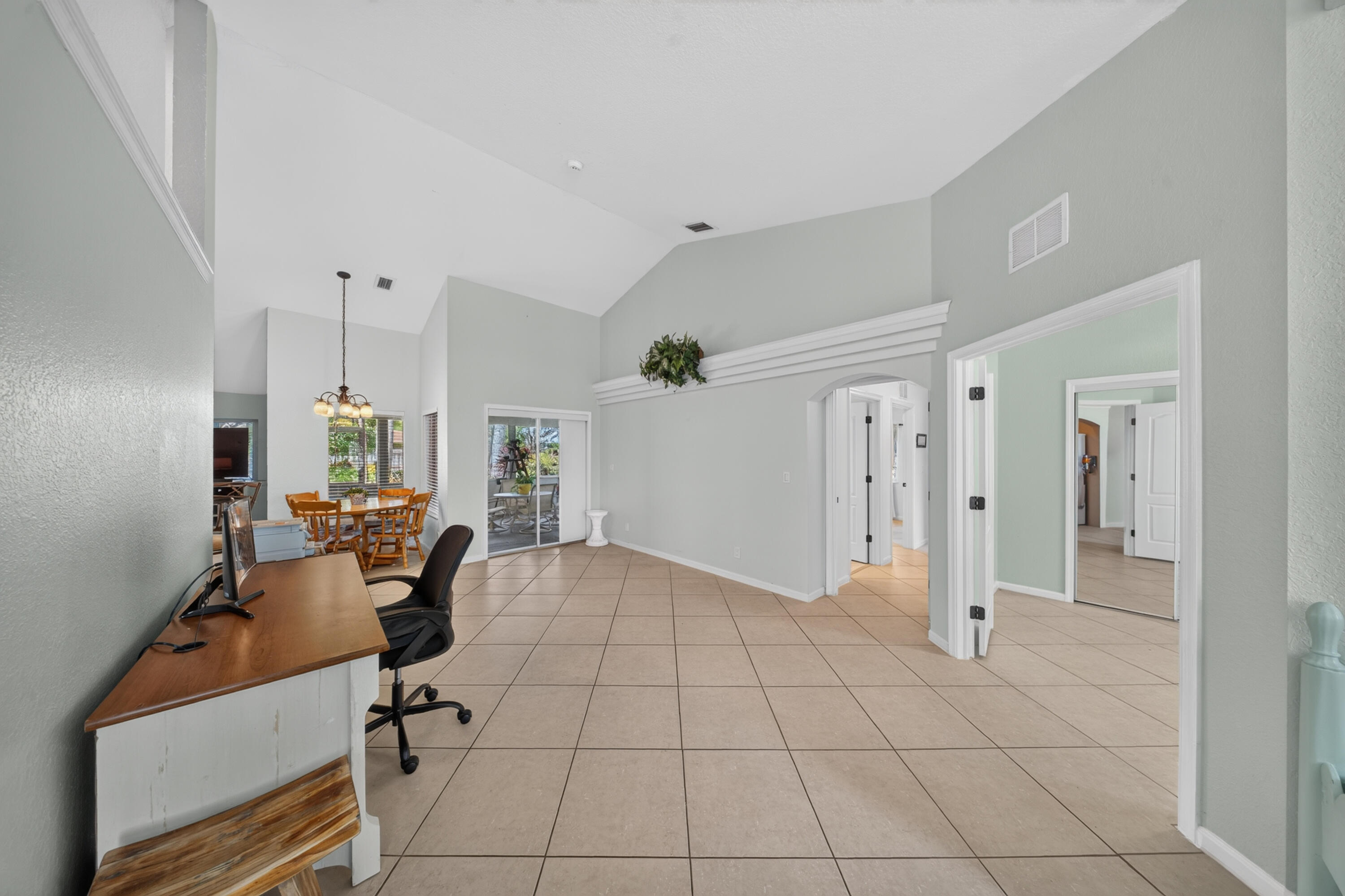Vaulted ceilings enhance the expansive tile flooring throughout