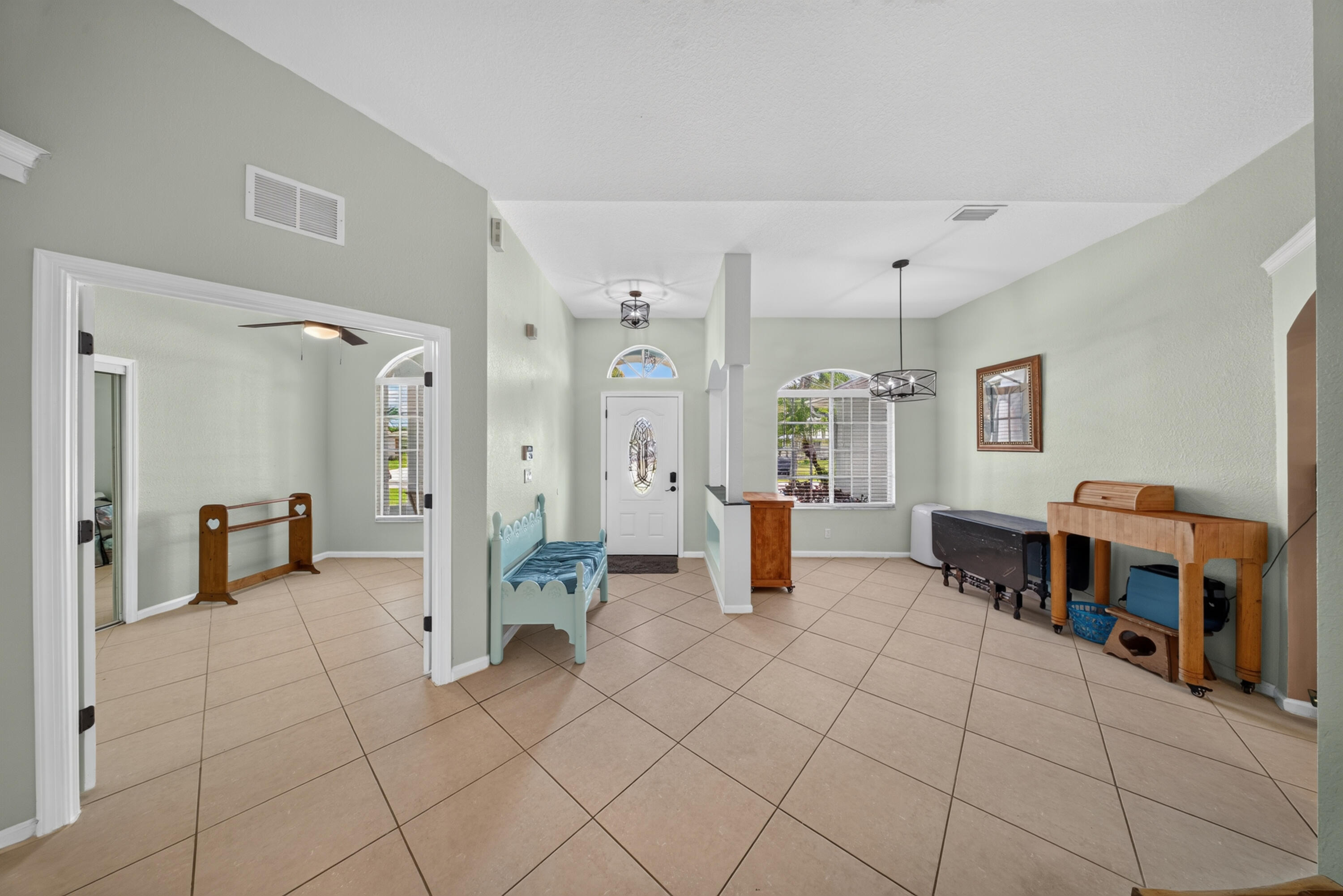 Vaulted ceilings, tile flooring, arched windows, transom window above the entrance, and recessed lighting