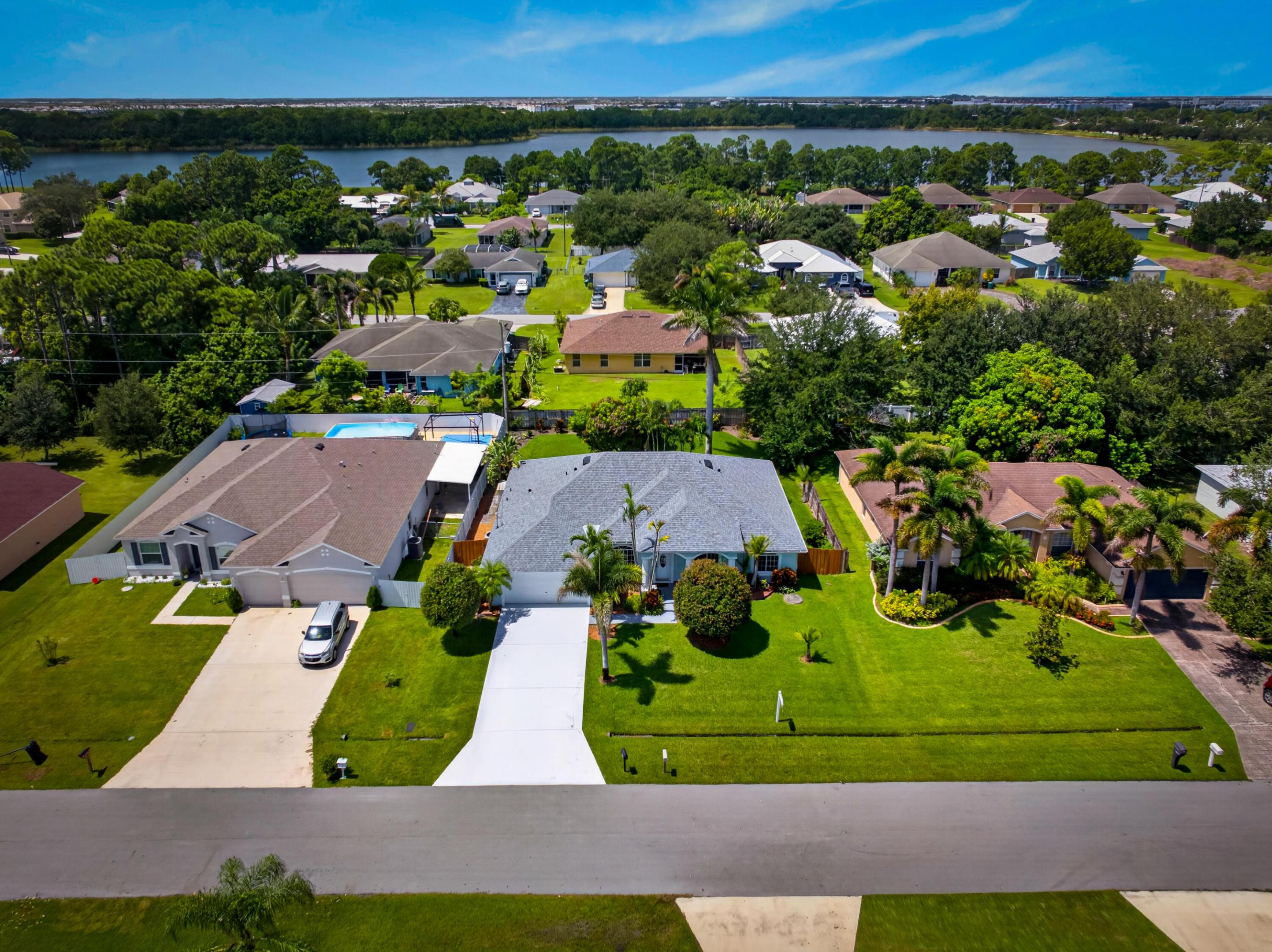 Aerial perspective showcasing a residential street, manicured lawns, and mature landscaping