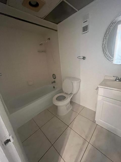 White tile flooring throughout with a white vanity and integrated sink