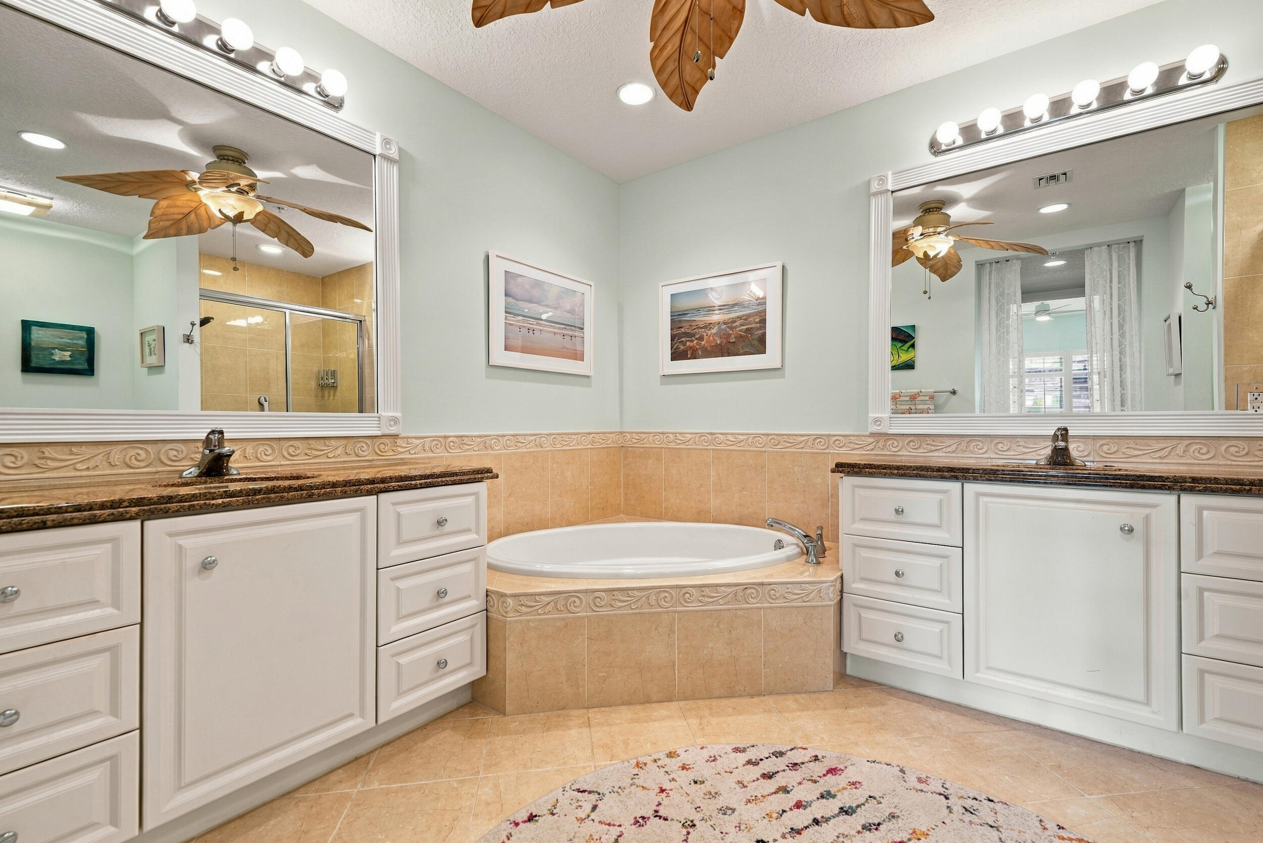 Primary bath with deep soaking tub, separate shower, two walk-in closets, and dual vanities