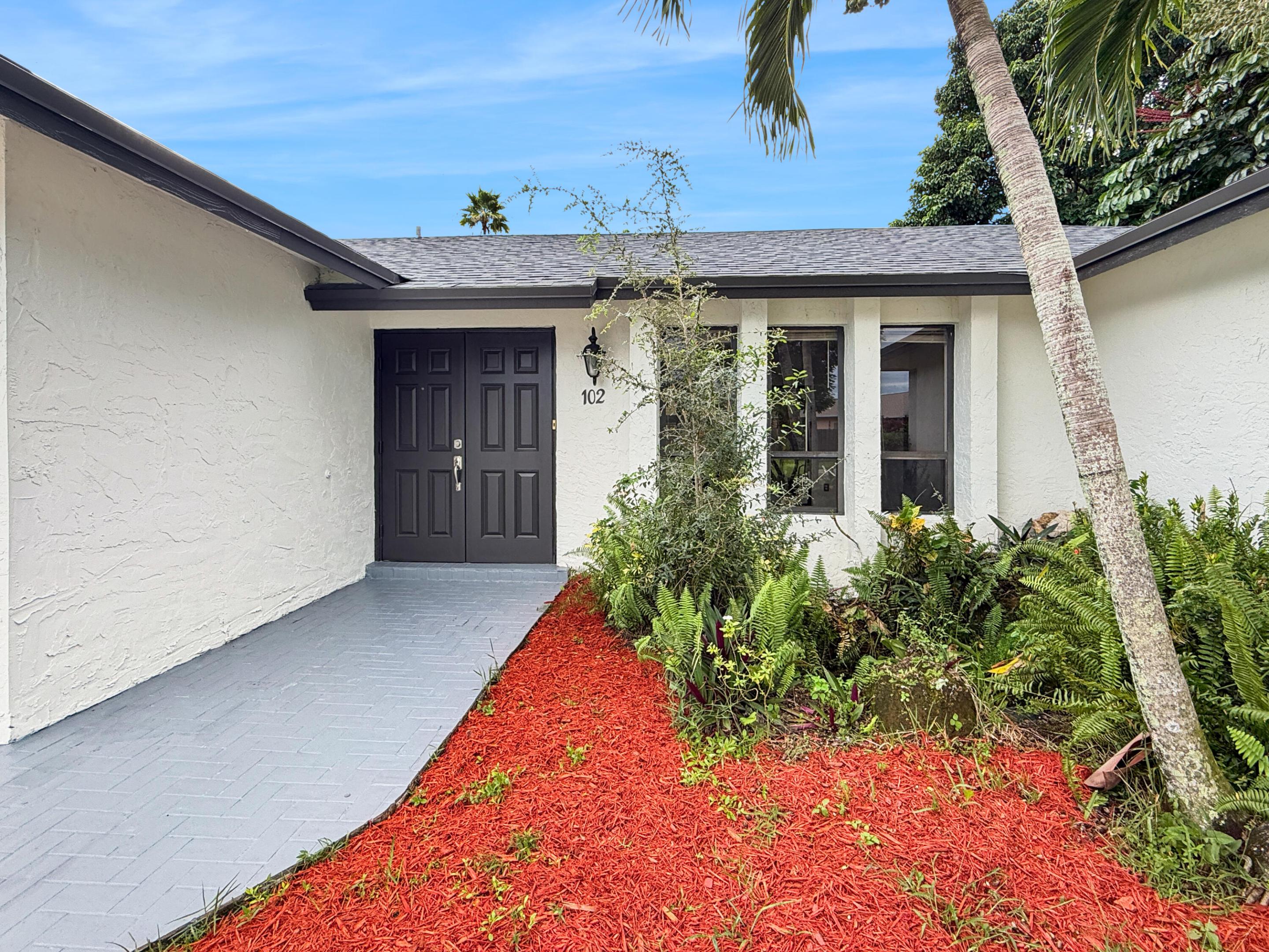 White stucco exterior with a gray shingle roof