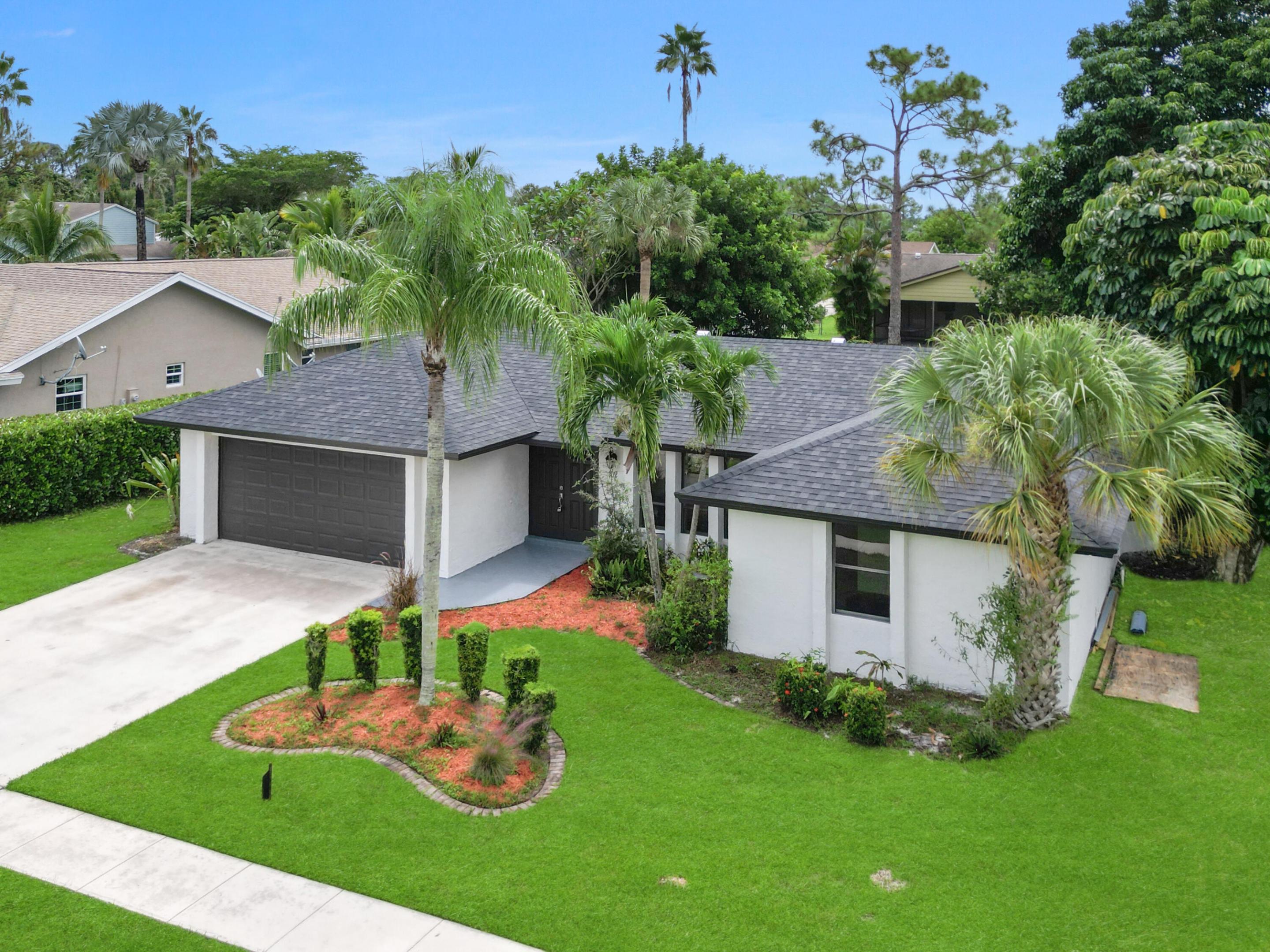Exterior featuring a dark shingle roof, white stucco facade, and an attached two-car garage